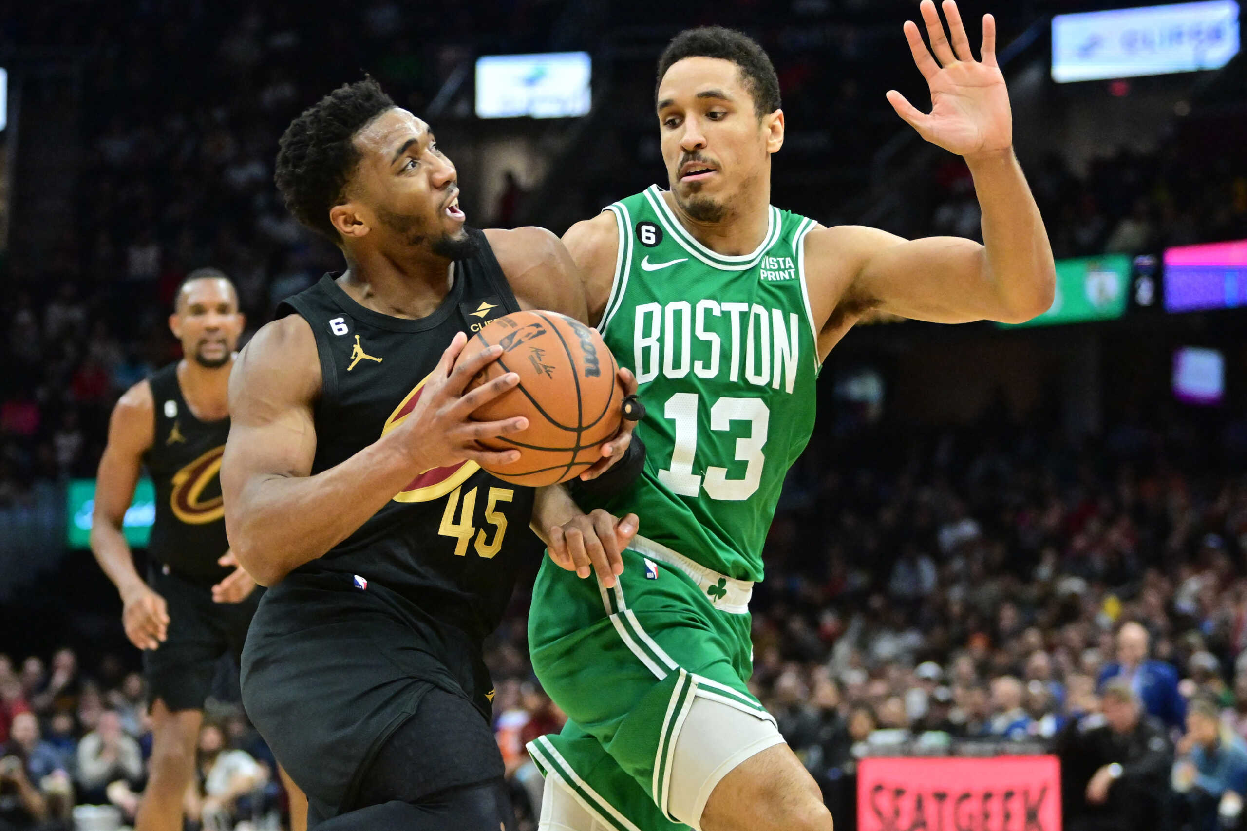 Mar 6, 2023; Cleveland, Ohio, USA; Cleveland Cavaliers guard Donovan Mitchell (45) drives to the basket against Boston Celtics guard Malcolm Brogdon (13) during the second half at Rocket Mortgage FieldHouse. Mandatory Credit: Ken Blaze-USA TODAY Sports