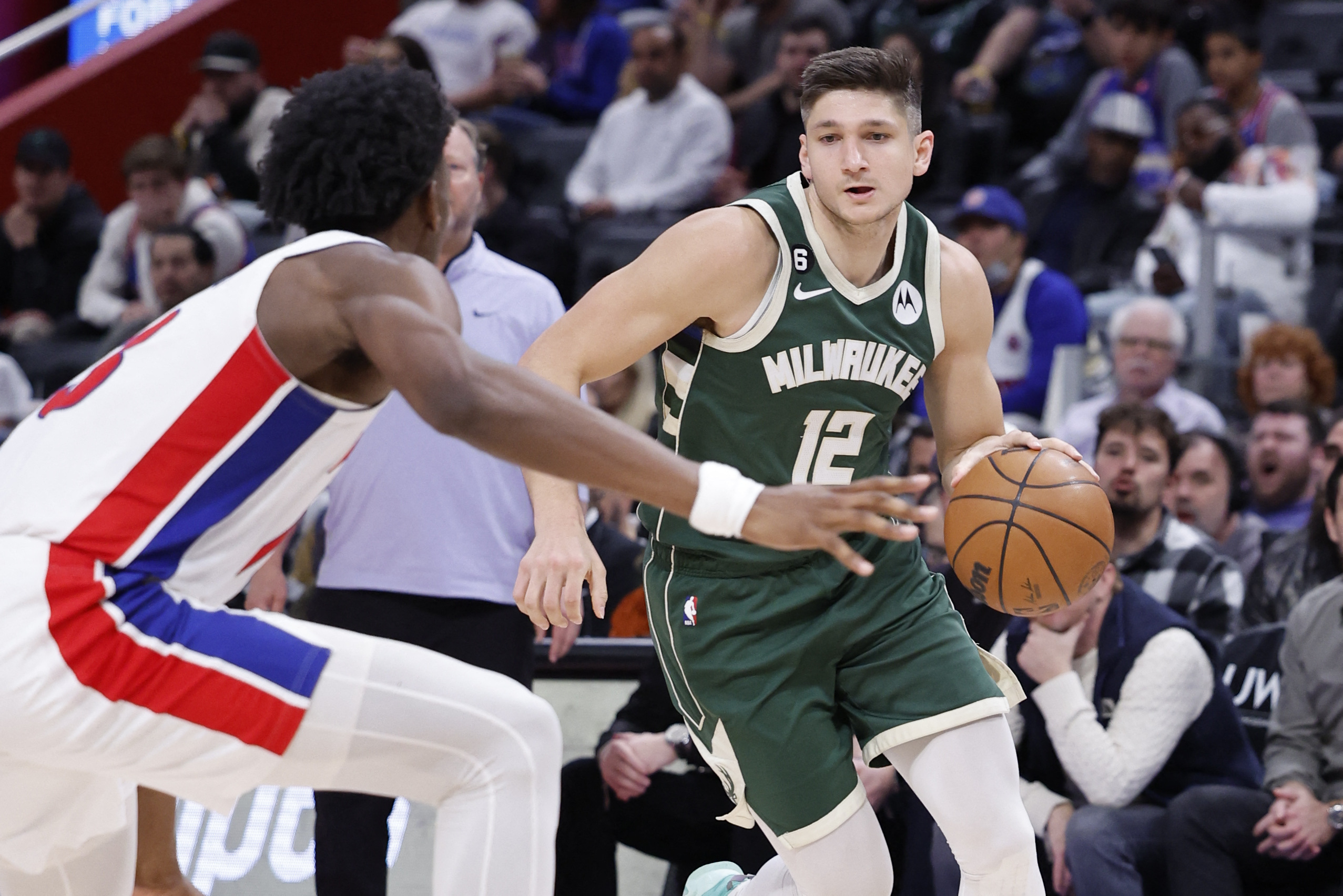 Mar 27, 2023; Detroit, Michigan, USA;  Milwaukee Bucks guard Grayson Allen (12) dribbles defended by Detroit Pistons center James Wiseman (13) in the second half at Little Caesars Arena. Mandatory Credit: Rick Osentoski-USA TODAY Sports