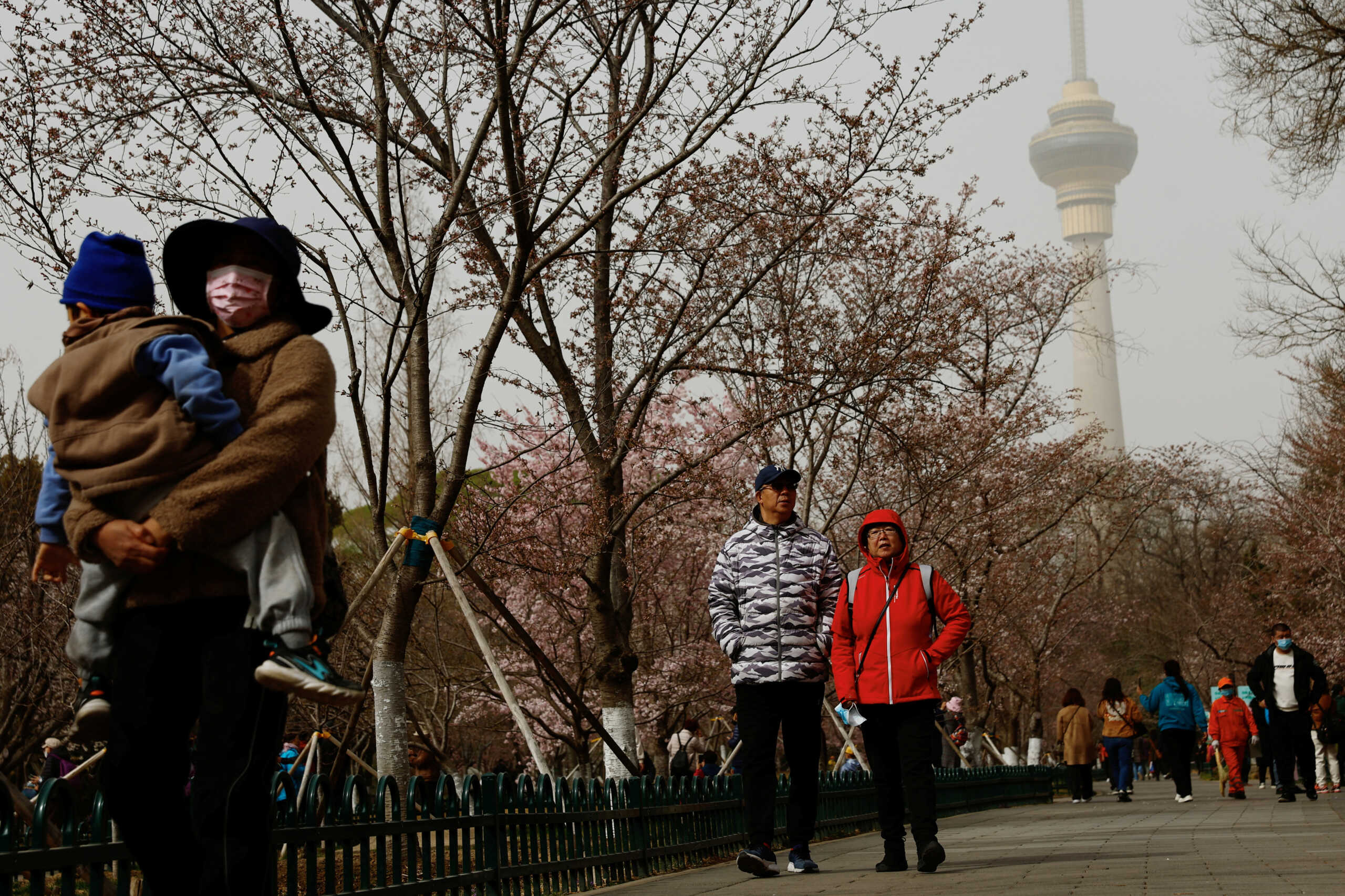 People walk amid a sandstorm at a park in Beijing, China March 22, 2023. REUTERS