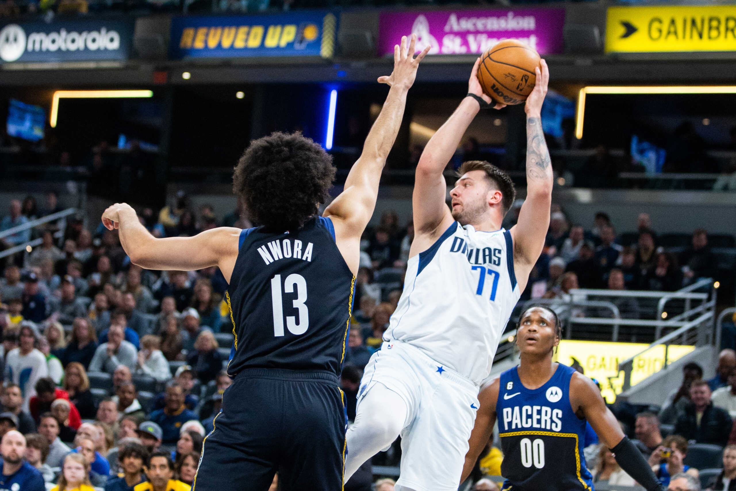 Mar 27, 2023; Indianapolis, Indiana, USA; Dallas Mavericks guard Luka Doncic (77) shoots the ball while Indiana Pacers forward Jordan Nwora (13) defends in the first quarter at Gainbridge Fieldhouse. Mandatory Credit: Trevor Ruszkowski-USA TODAY Sports