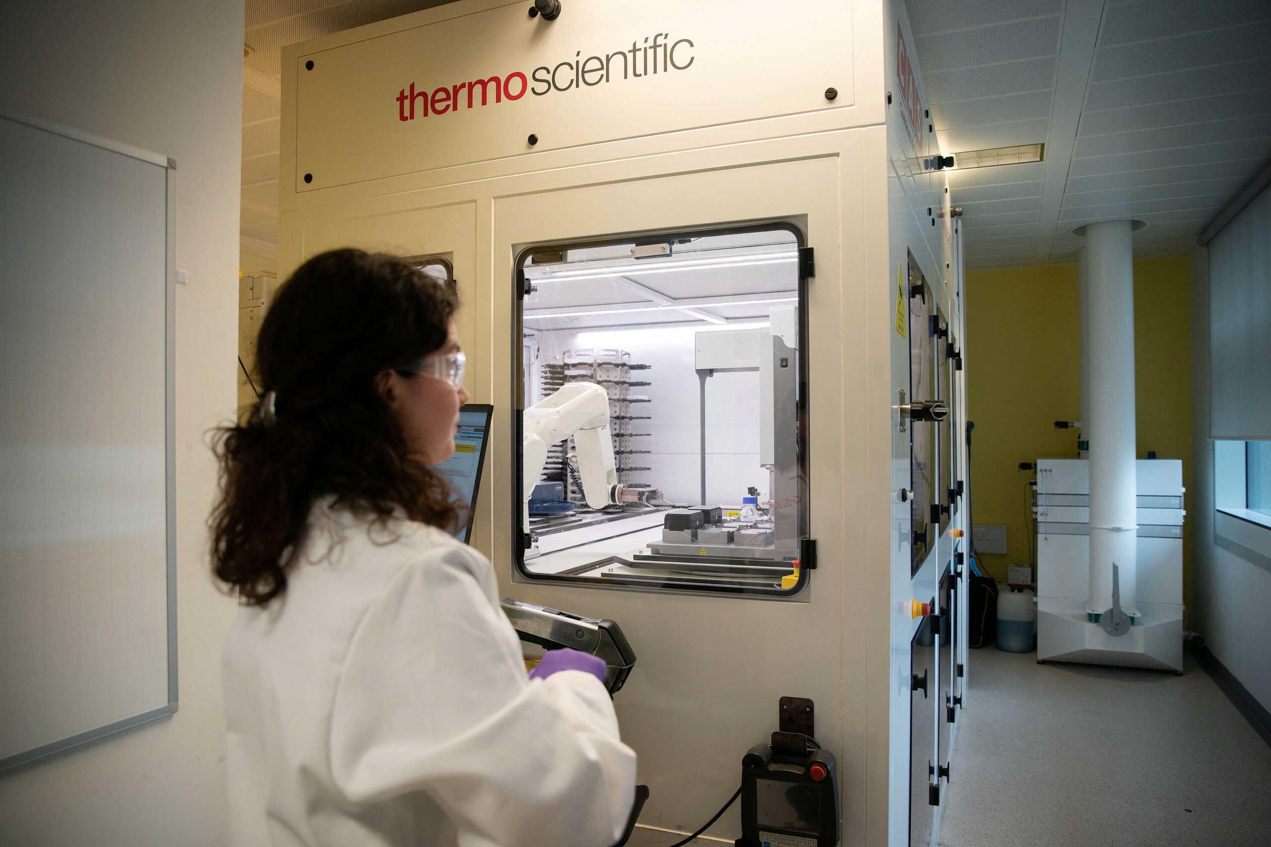 Senior Scientist Alice Rockliffe works with a robot, the Cellular Automated Screening Platform, which runs cell-based screening assays, at the GSK Research and Development centre in Stevenage, Britain, February 21, 2023. REUTERS