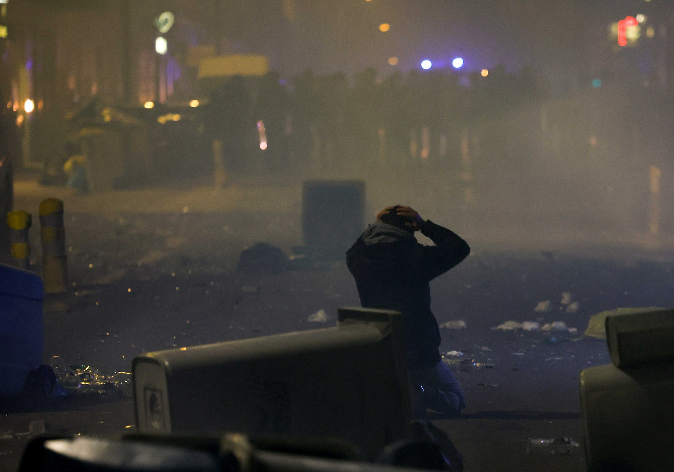 A demonstrator reacts while kneeling during a protest after French Prime Minister Elisabeth Borne used the article 49.3, a special clause in the French Constitution, to push the pensions reform bill through the National Assembly without a vote by lawmakers, in Nantes, France, March 16, 2023.  REUTERS