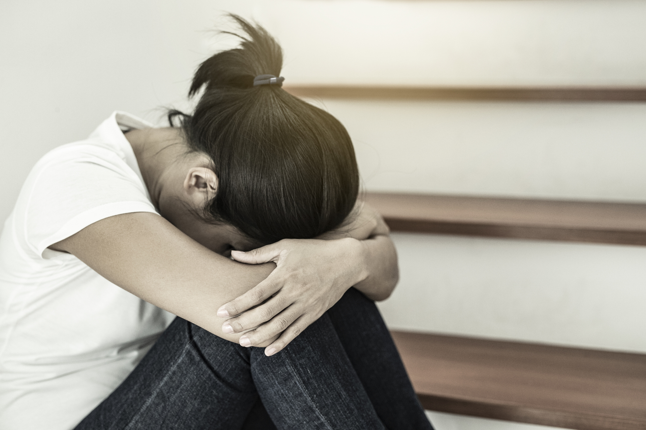 The depression woman alone sitting on staircase she thought so much and headaches, eye pain.