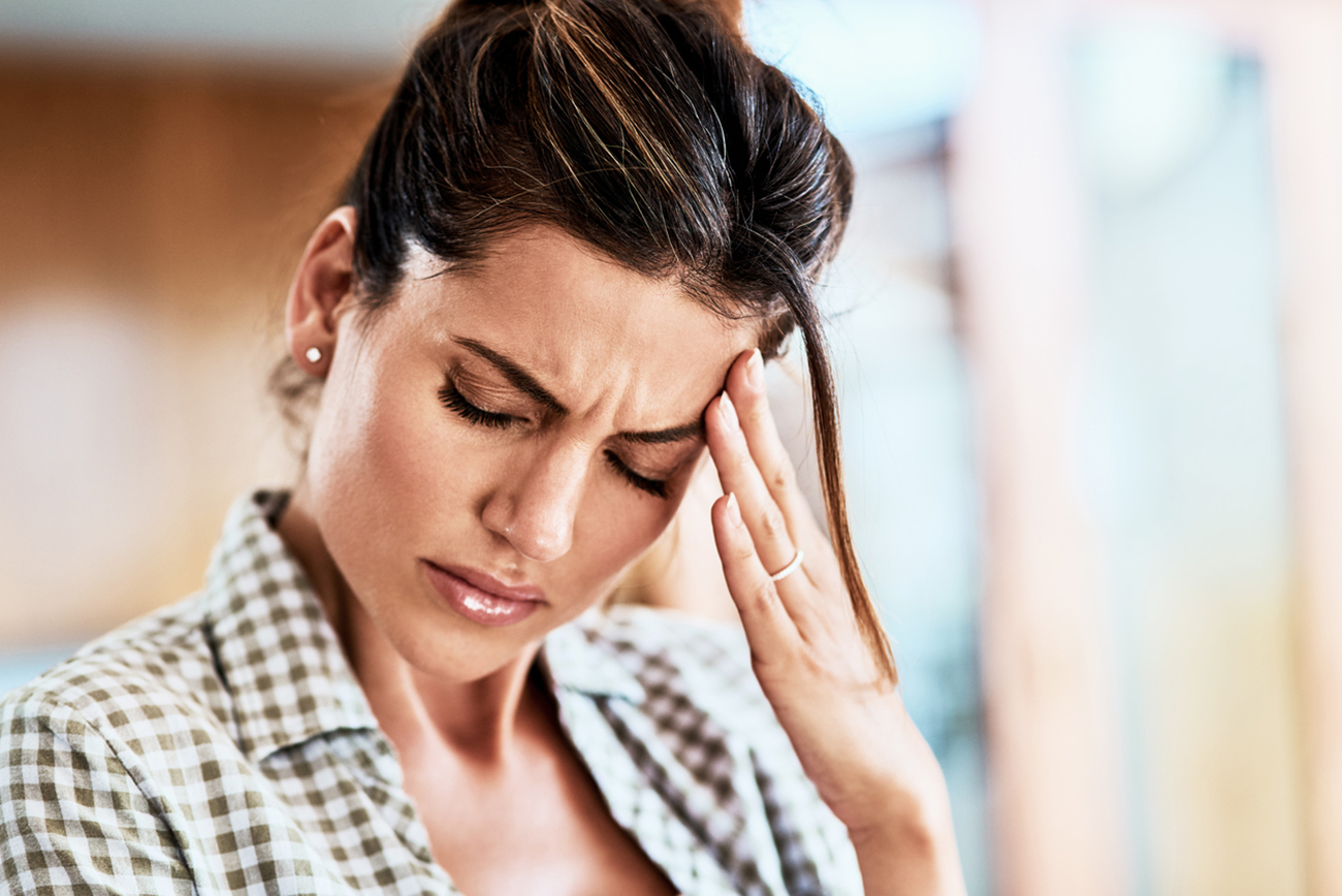Cropped shot of an attractive young woman suffering with a headache at home