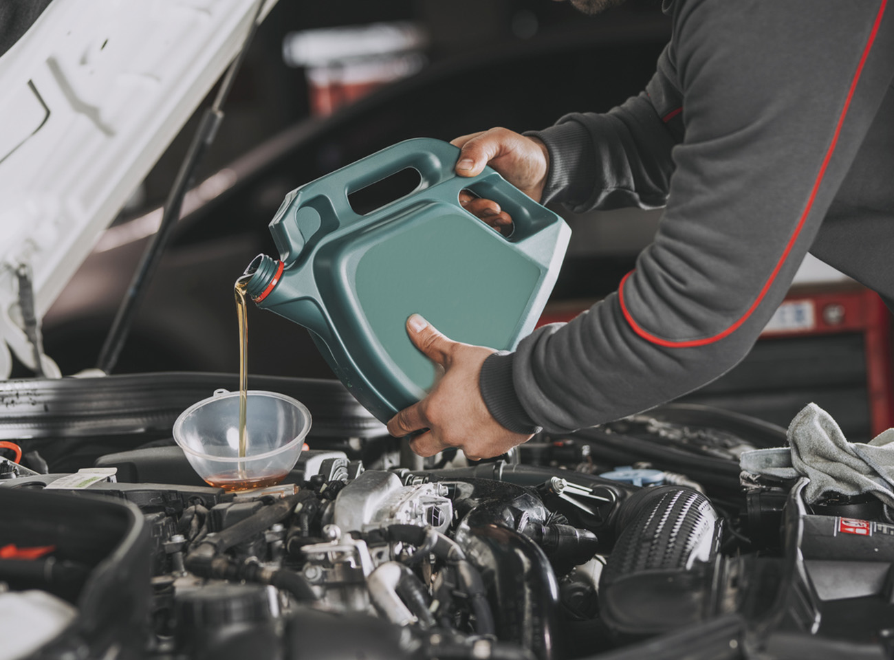Pouring oil to car engine.
