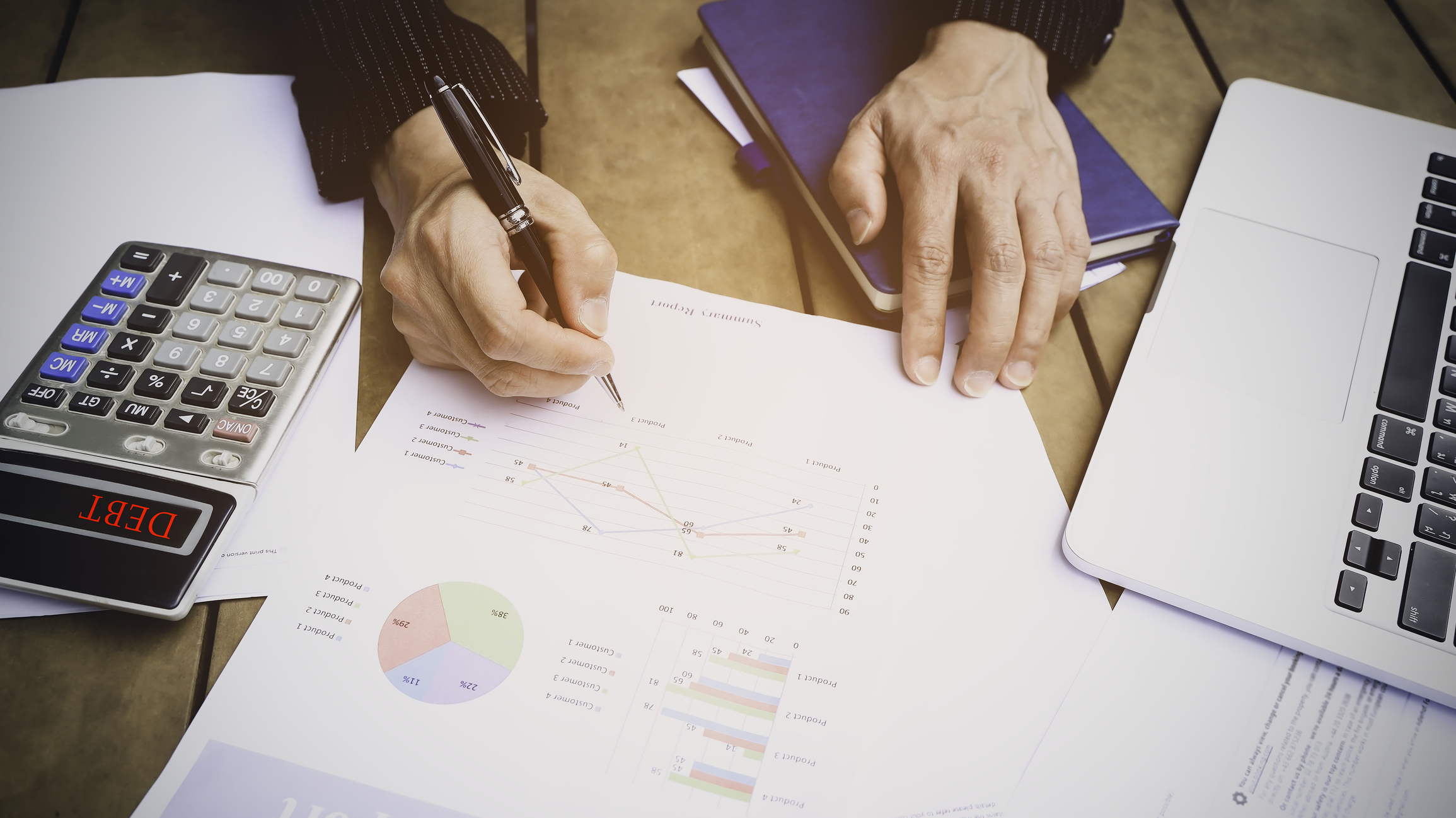 Selective focus man hand with pen check calculating the monthly of debt bills bank as a papers graph documents expenses and payment in the office
