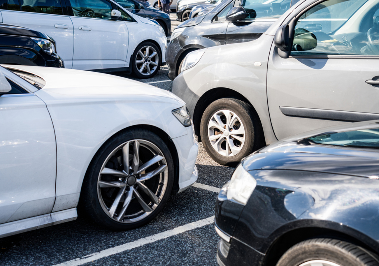 A group of cars parked in marked bays.