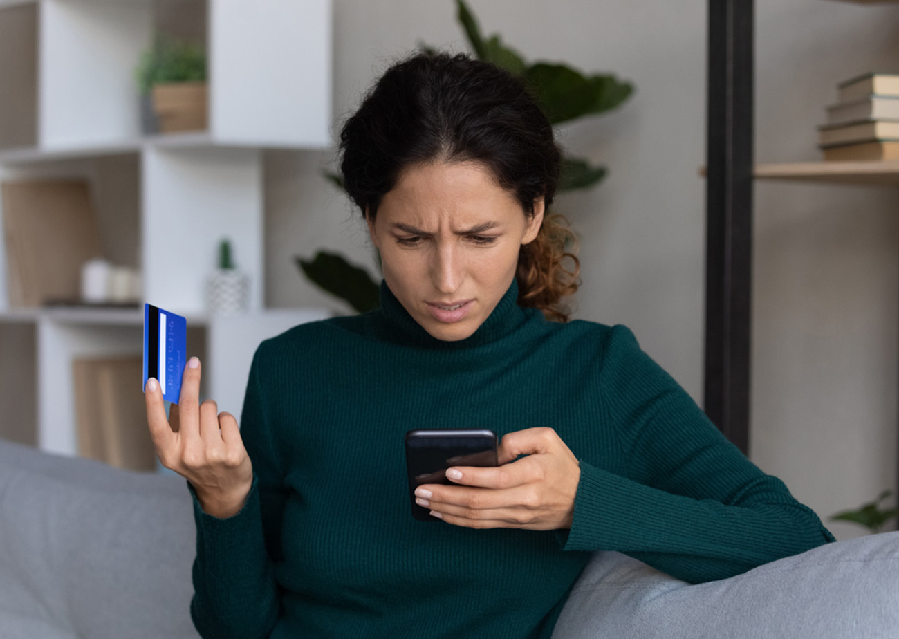 Internet scam. Concerned young hispanic lady looking on smartphone screen having finance savings stolen from bank card as money fraud result. Upset nervous latin woman become online scammers victim