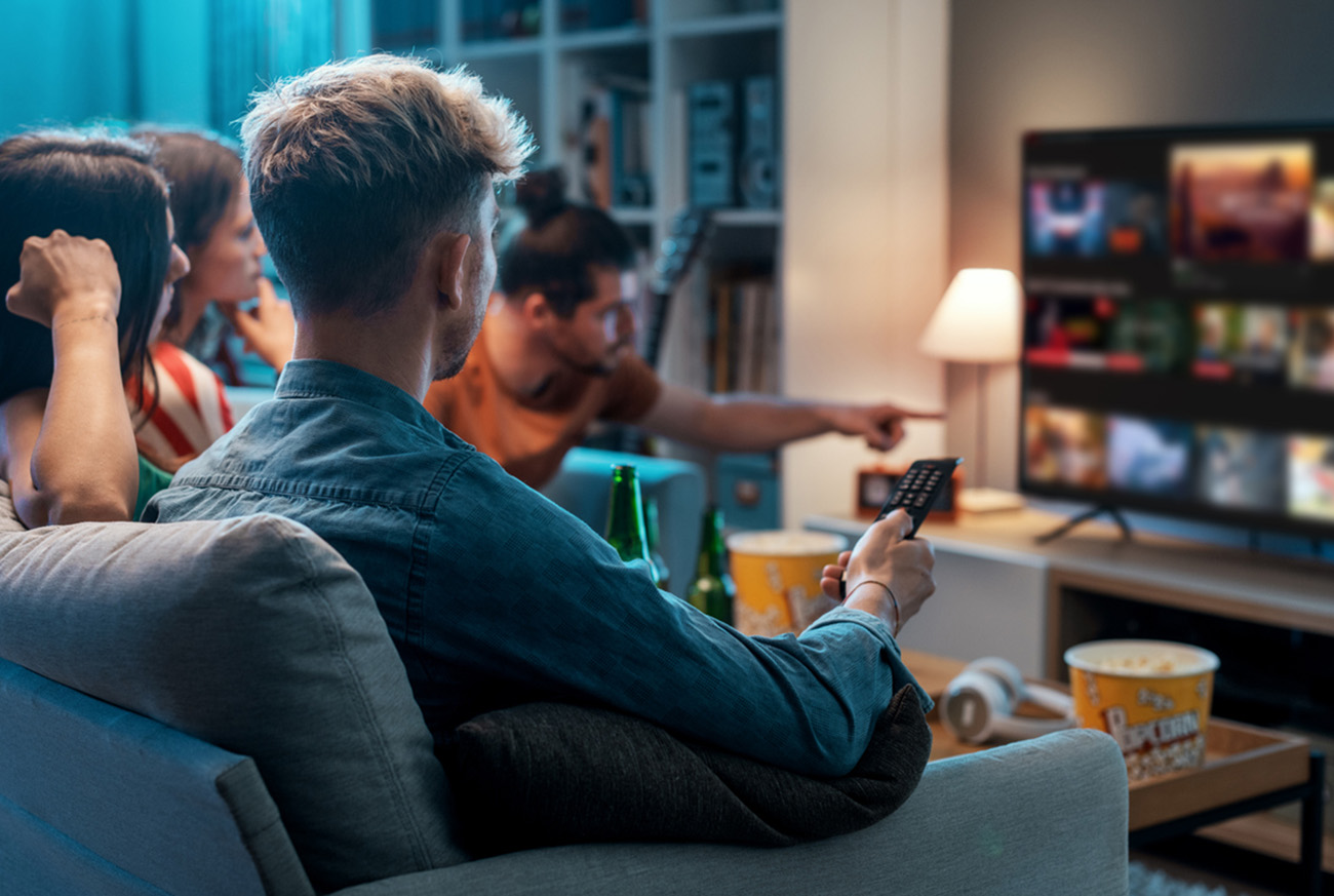 Friends choosing a movie to watch together at home, video on demand concept