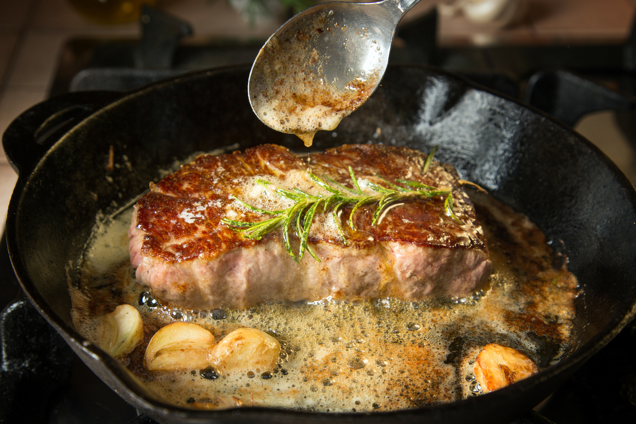 Preparing beef strip loin steak on an iron pan.