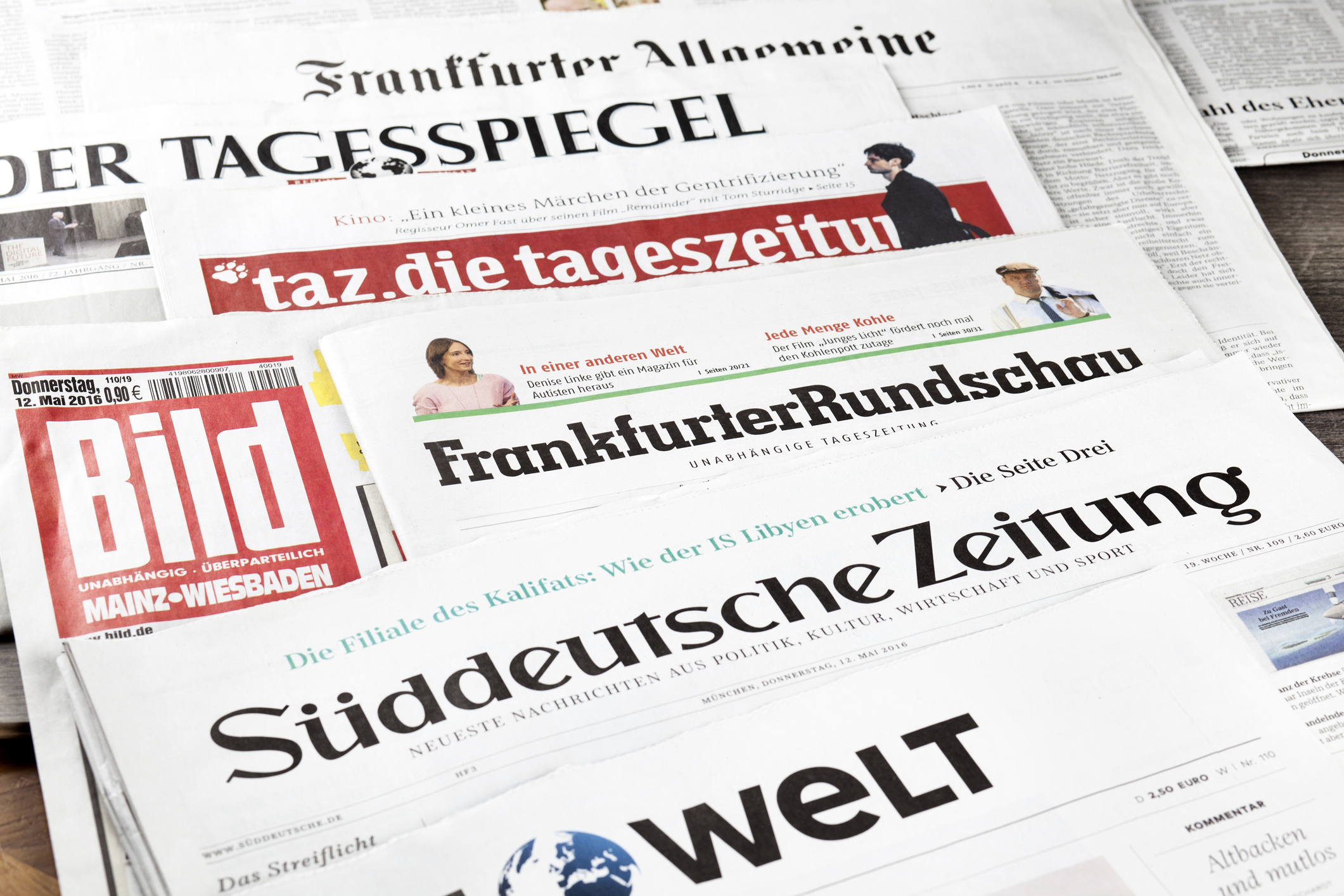 Wiesbaden, Germany - June 3, 2016: German press review. Assortment of well-known german newspapers with a wide circulation: Frankfurter Rundschau, BILD, taz, Frankfurter Allgemeine, Der Tagesspiegel,  Sueddeutsche Zeitung, Die Welt. Studio shot.