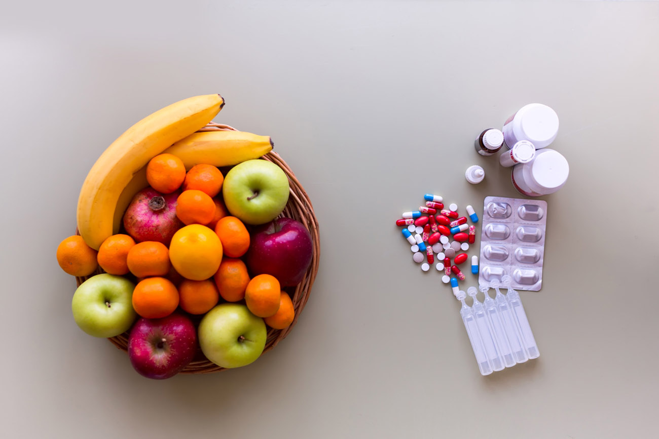 Colorful fresh fruits and pills. Make your choise. Healthy lifestyle concept. Top view.
