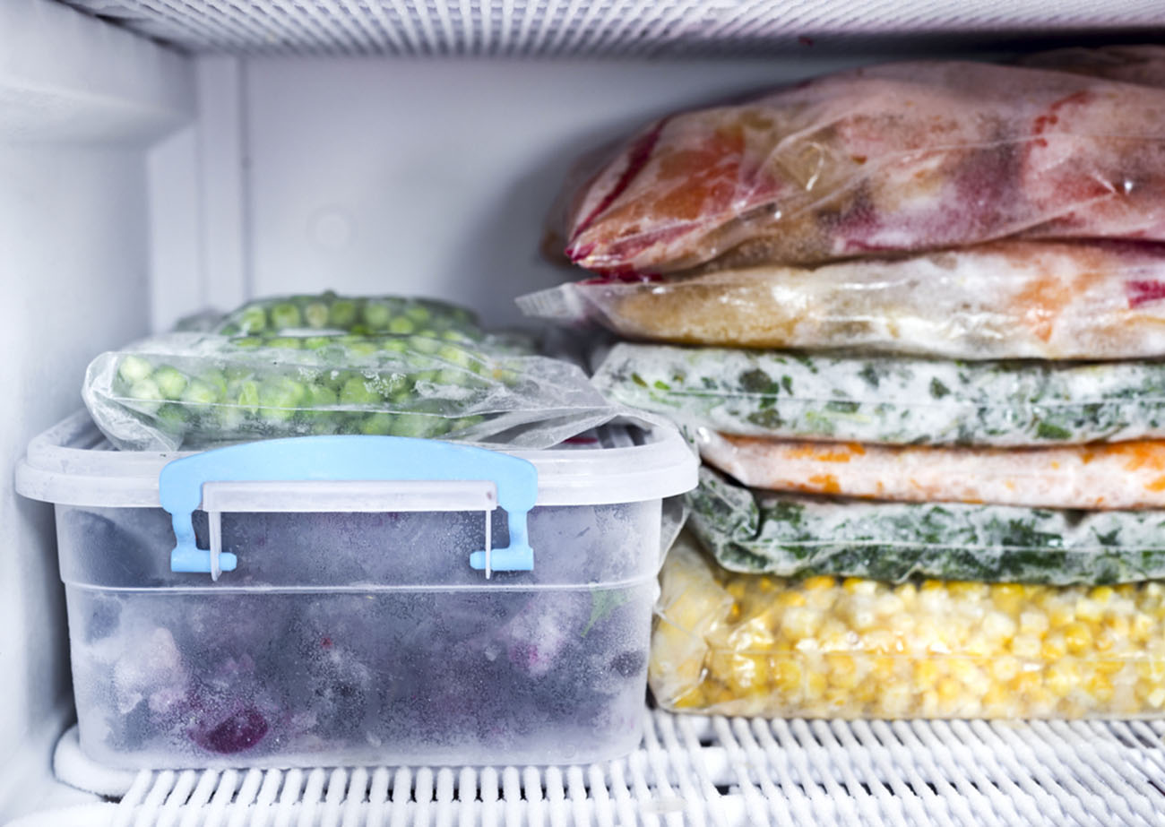 Frozen berries and vegetables in bags in freezer close up