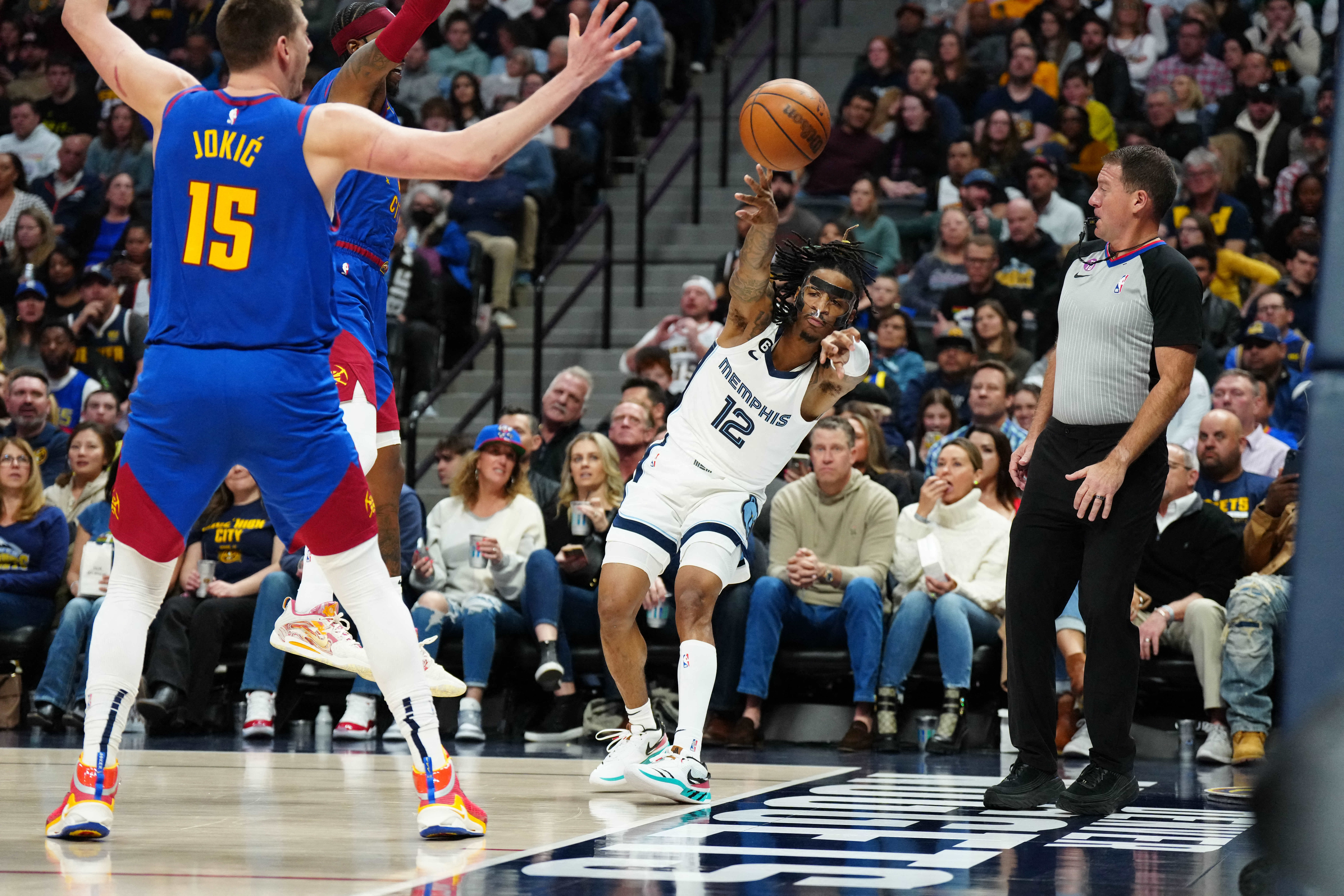 Mar 3, 2023; Denver, Colorado, USA; Memphis Grizzlies guard Ja Morant (12) passes the ball against Denver Nuggets center Nikola Jokic (15) during the second quarter at Ball Arena. Mandatory Credit: Ron Chenoy-USA TODAY Sports