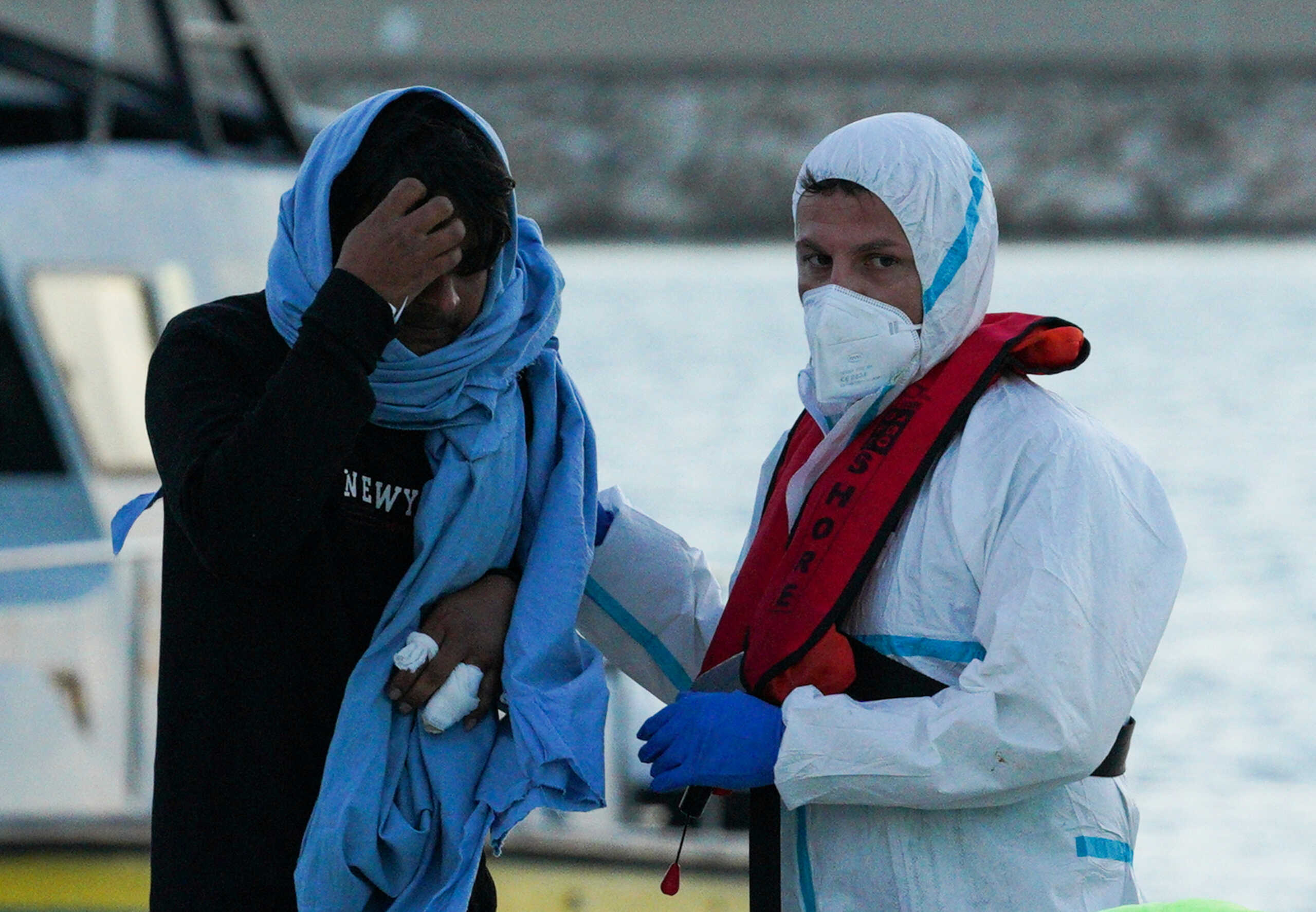 A migrant who survived a deadly shipwreck in the central Mediterranean receives help as he disembarks in the Sicilian harbour of Pozzallo, Italy, March 13, 2023. REUTERS