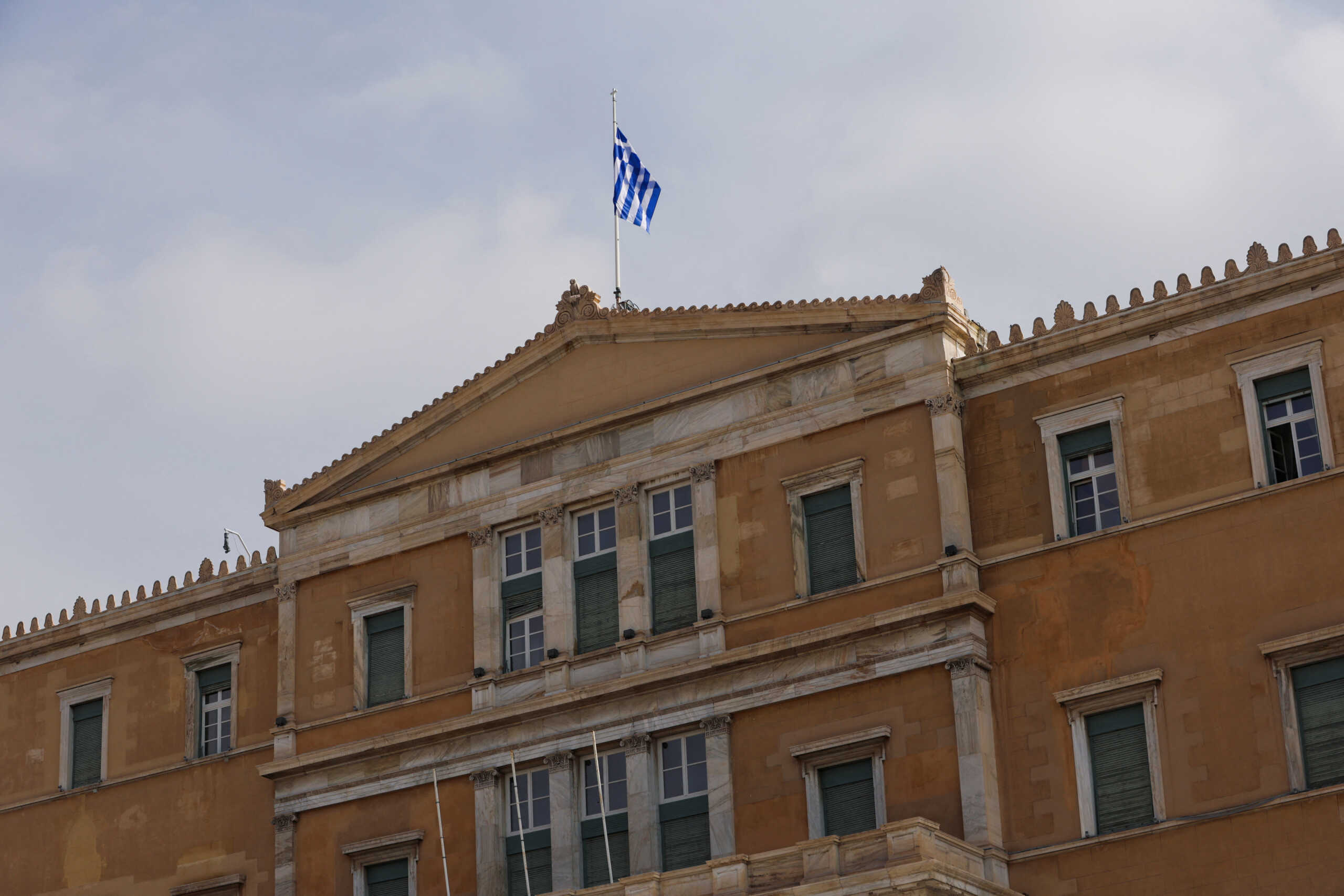 A Greek flag flutters atop the parliament building in Athens, Greece, March 1, 2023. REUTERS