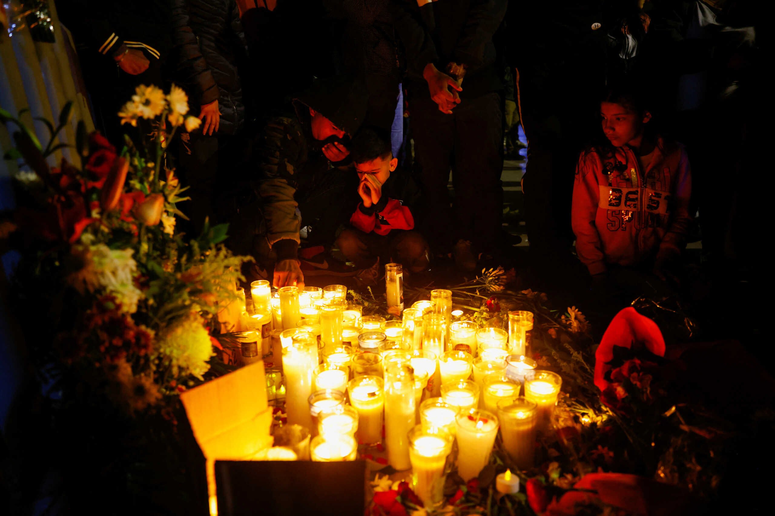 Migrants hold a candle vigil outside the office of the National Institute of Migration (INM) in memory of the victims of a fire that broke out late on Monday at a migrant detention center, in Ciudad Juarez, Mexico, March 28, 2023. REUTERS