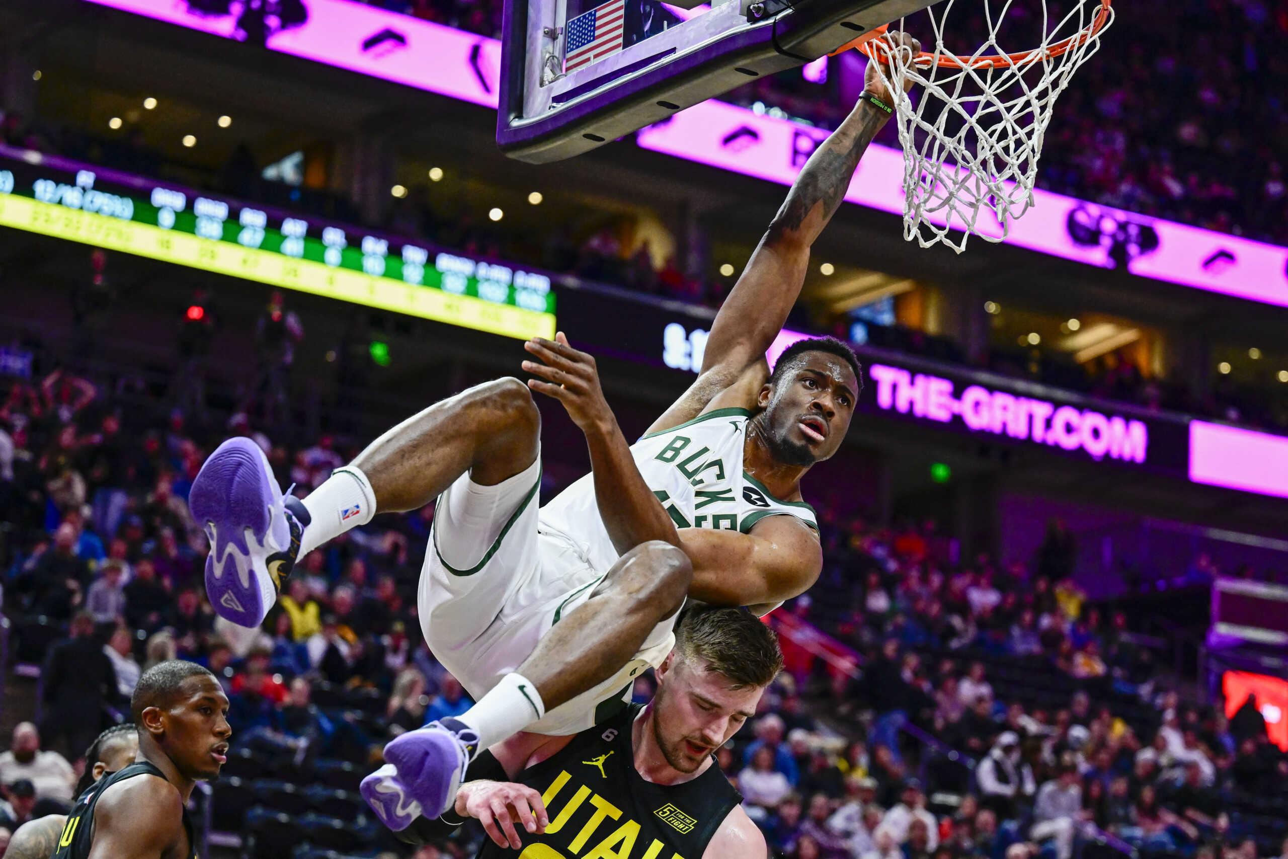 Mar 24, 2023; Salt Lake City, Utah, USA; Milwaukee Bucks forward Thanasis Antetokounmpo (43) hangs onto the rim after a dunk over Utah Jazz center Micah Potter (25) during the second half at Vivint Arena. Mandatory Credit: Christopher Creveling-USA TODAY Sports