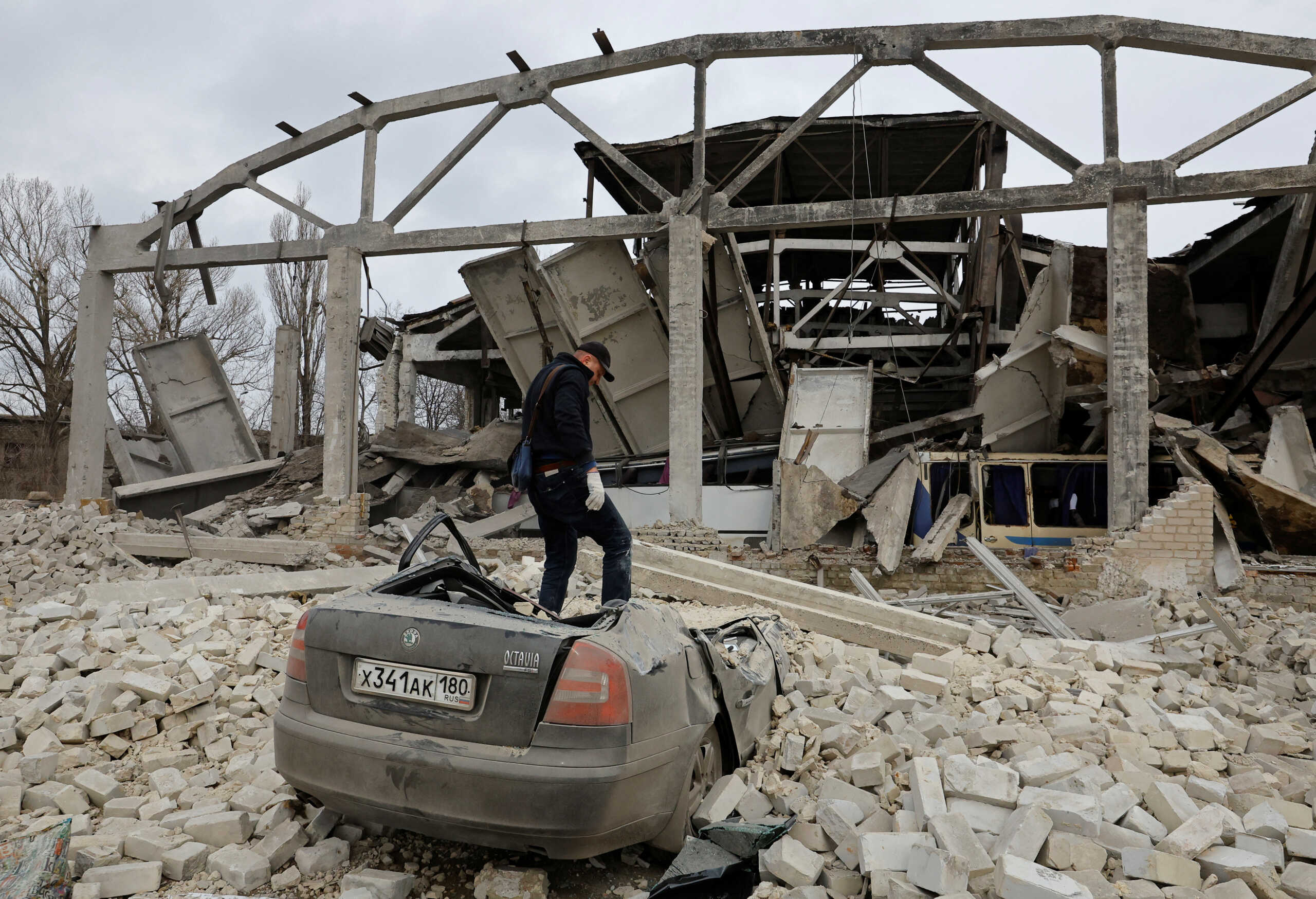 Bus driver Sergei, 49, stands on the wreckage of his car, destroyed by recent shelling in the course of Russia-Ukraine conflict, at a bus depot in the town of Volnovakha in the Donetsk region, Russian-controlled Ukraine, March 9, 2023. REUTERS