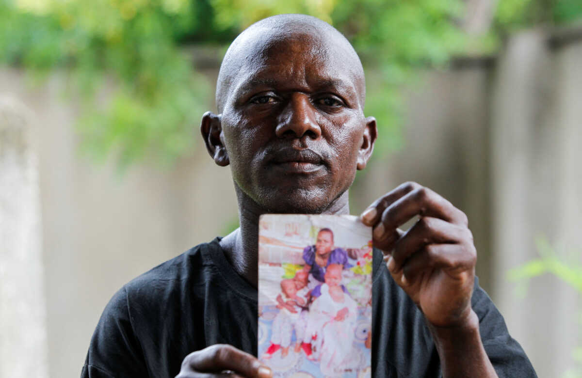 Steven Mwiti holds a photograph of his late wife Joan Bahati, a follower of a Christian cult named "Good News International Church", who believed they would go to heaven, if they starved themselves to death alongside his six children in Shakahola, outside the Malindi sub district hospital mortuary in Malindi, Kilifi county, Kenya April 26, 2023. REUTERS