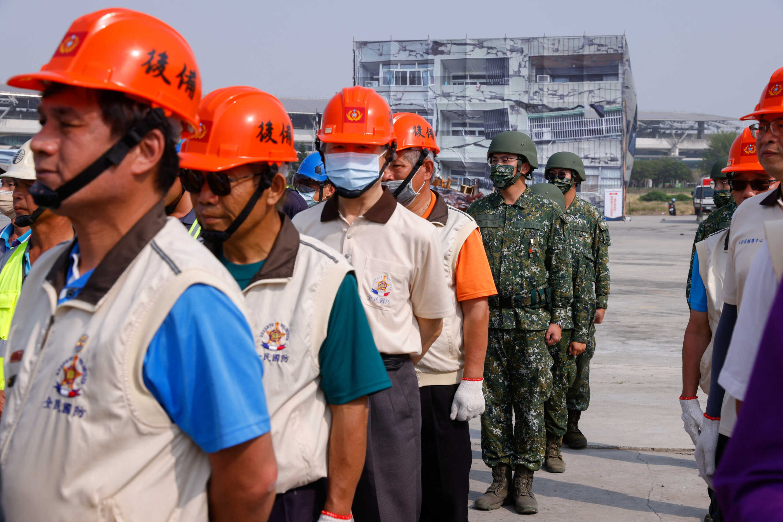 Civilians and soldiers stand during the annual Minan civilian defense drill, which this years focuses on the response from various agencies and volunteer groups if under attack by China, in Taichung, Taiwan April 13, 2023. REUTERS