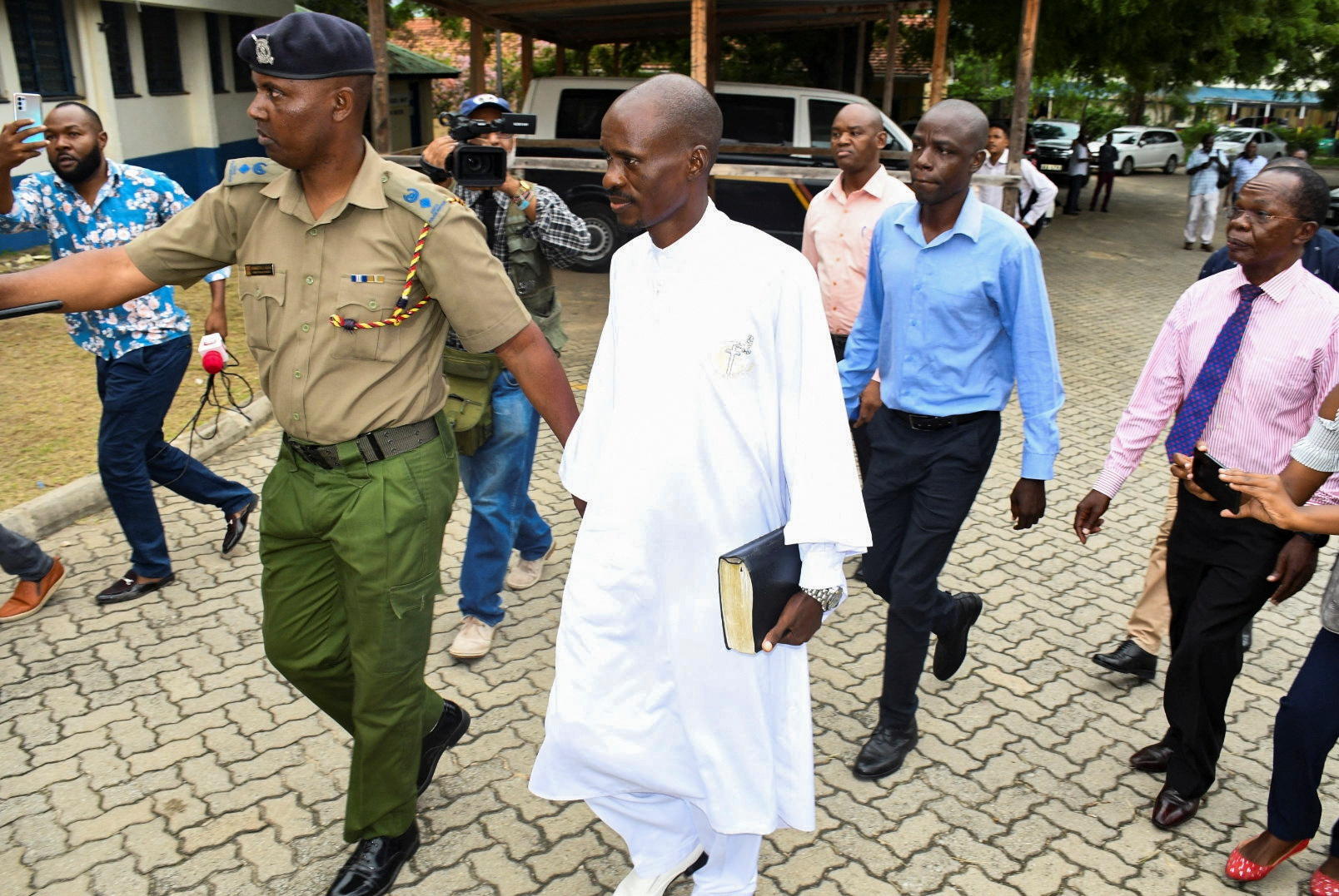 Detectives escort Ezekiel Ombok Odero, the Head of New Life Prayer Centre
