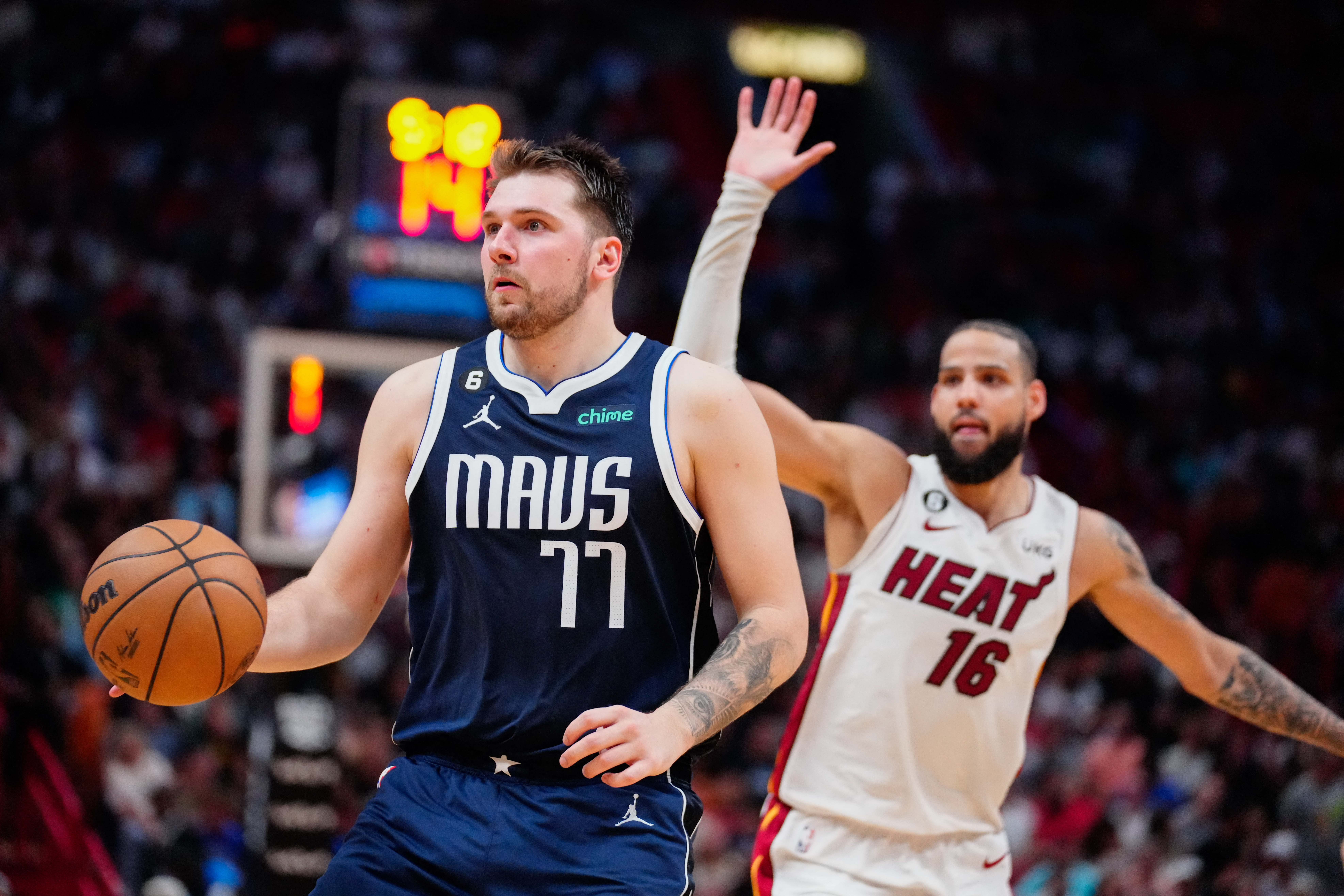 Apr 1, 2023; Miami, Florida, USA; Dallas Mavericks guard Luka Doncic (77) looks to pass as Miami Heat forward Caleb Martin (16) defends during the fourth quarter at Miami-Dade Arena. Mandatory Credit: Rich Storry-USA TODAY Sports