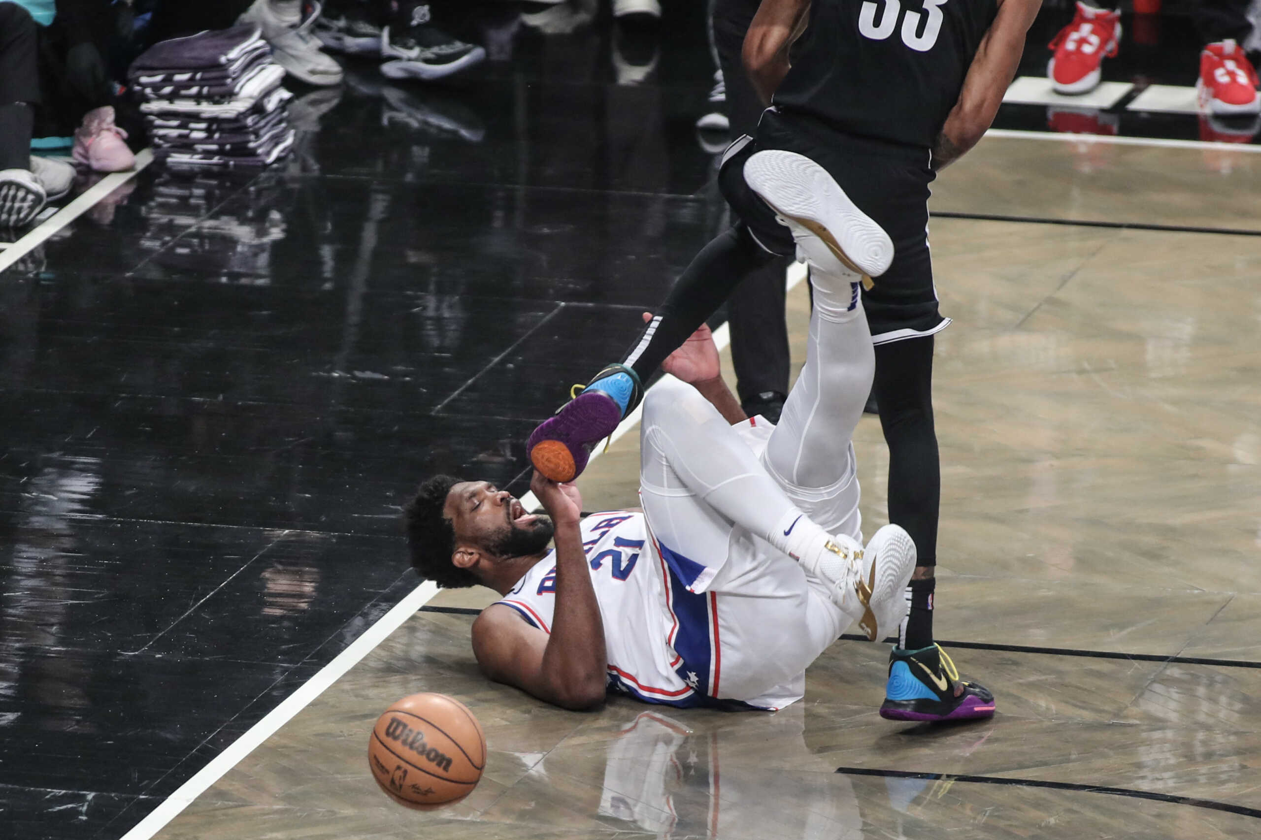 Apr 20, 2023; Brooklyn, New York, USA; Philadelphia 76ers center Joel Embiid (21) falls to the floor after colliding with Brooklyn Nets center Nic Claxton (33) during game three of the 2023 NBA playoffs at Barclays Center. Mandatory Credit: Wendell Cruz-USA TODAY Sports