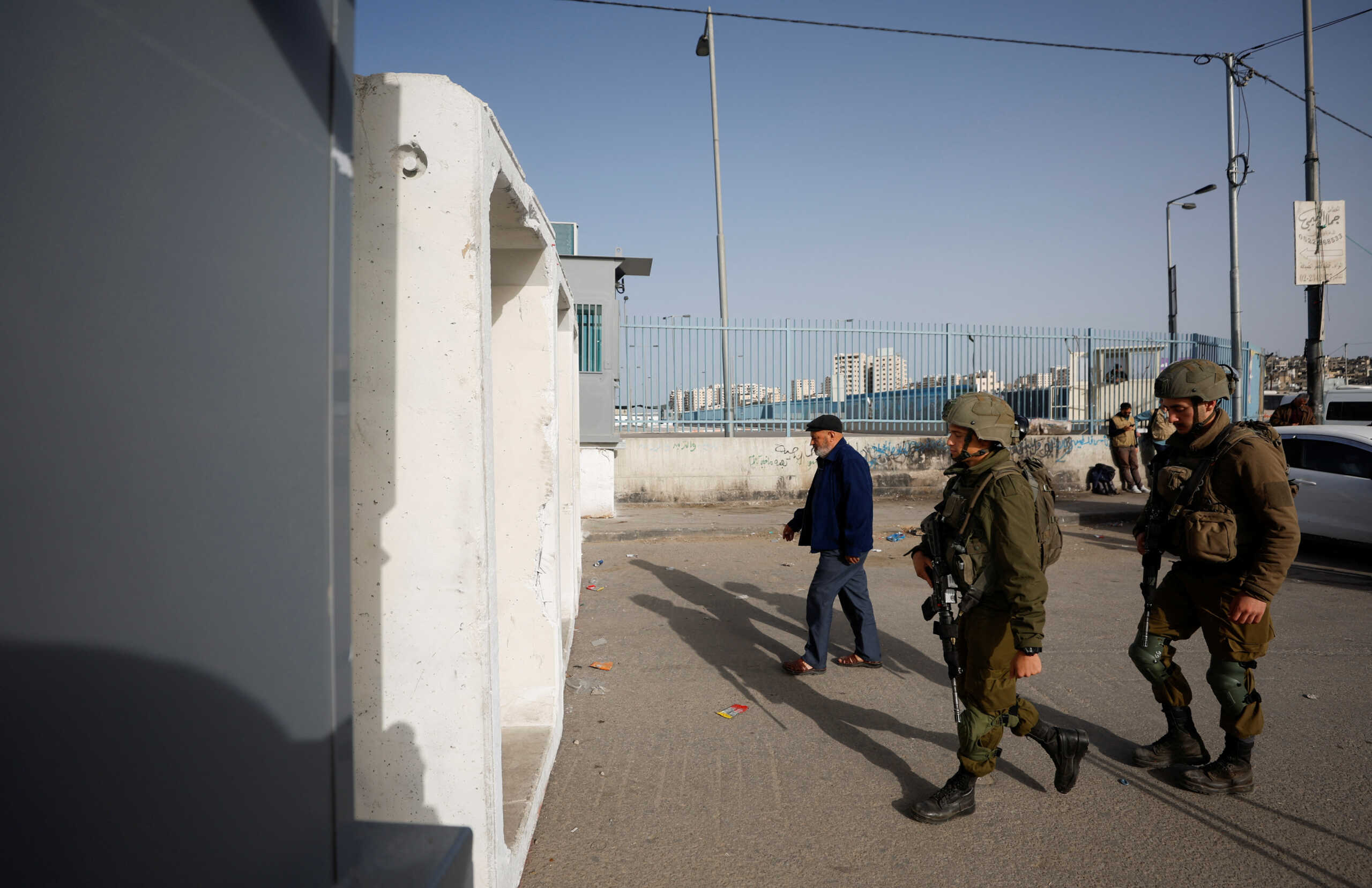 Law enforcement officers walk as Palestinians make their way to attend the Friday prayers of Ramadan in Jerusalem's Al-Aqsa mosque, at Qalandia checkpoint in the Israeli-occupied West Bank April 7, 2023. REUTERS