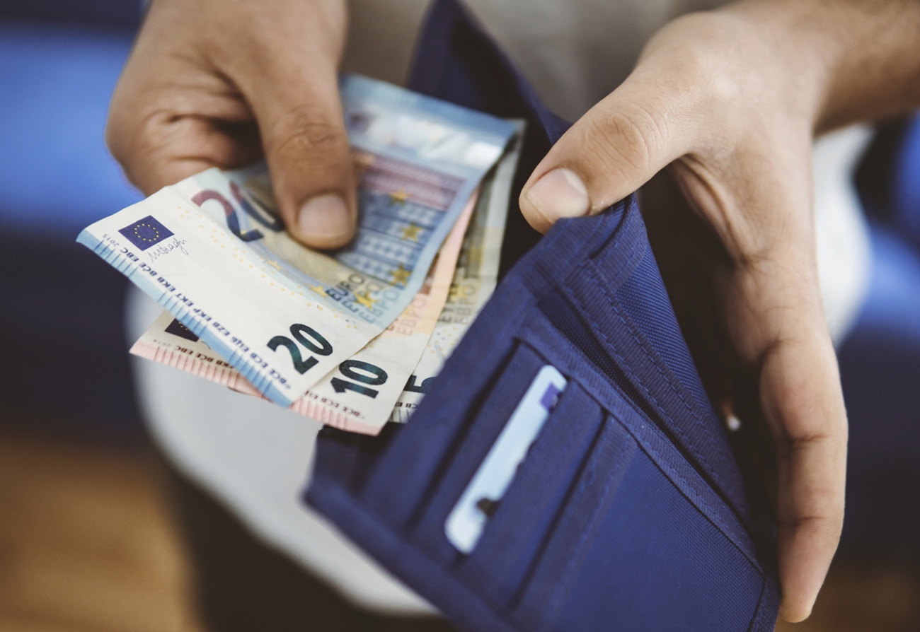 unrecognizable young man takes money out of his wallet. Horizontal composition.