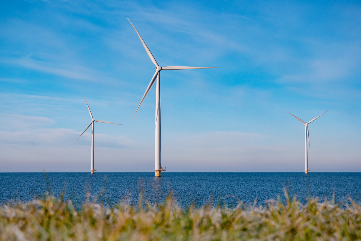 offshore windmill park with stormy clouds and a blue sky, windmill park in the ocean. Netherlands . Europe, windmill turbines in ocean with blue sky, green energy concept
