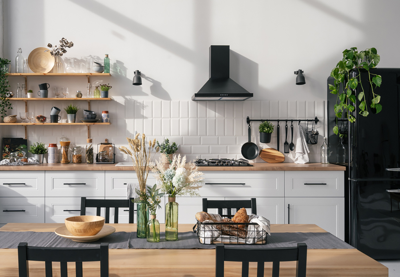 Kitchen interior with modern furniture, appliances and decor on table. Bright and spacious apartment. Luxury real estate for sale. Dining room design project