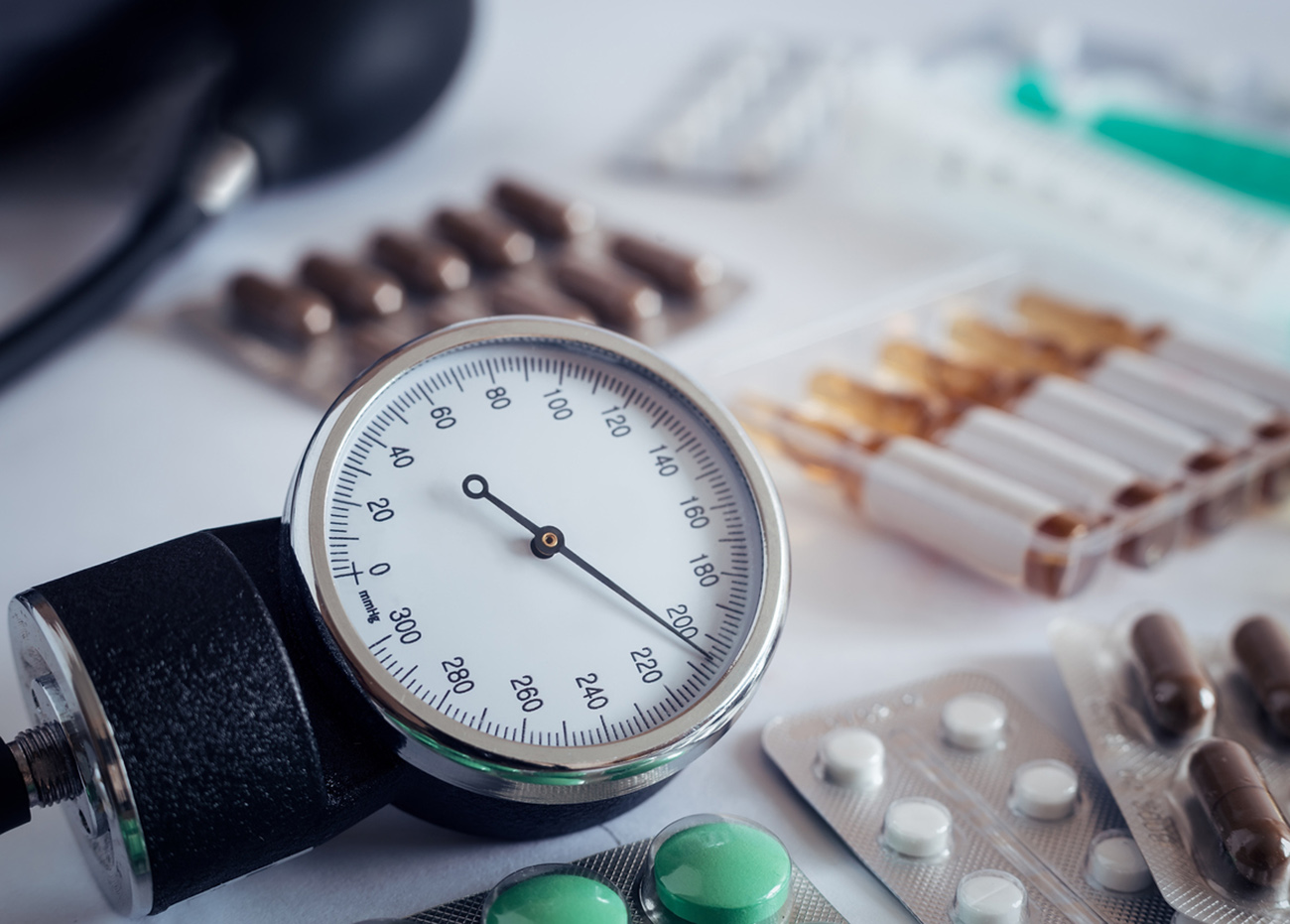 On the table is an apparatus for blood pressure measurement, which shows higher pressures. It's a hypertensive crisis. Near are medications to assist.