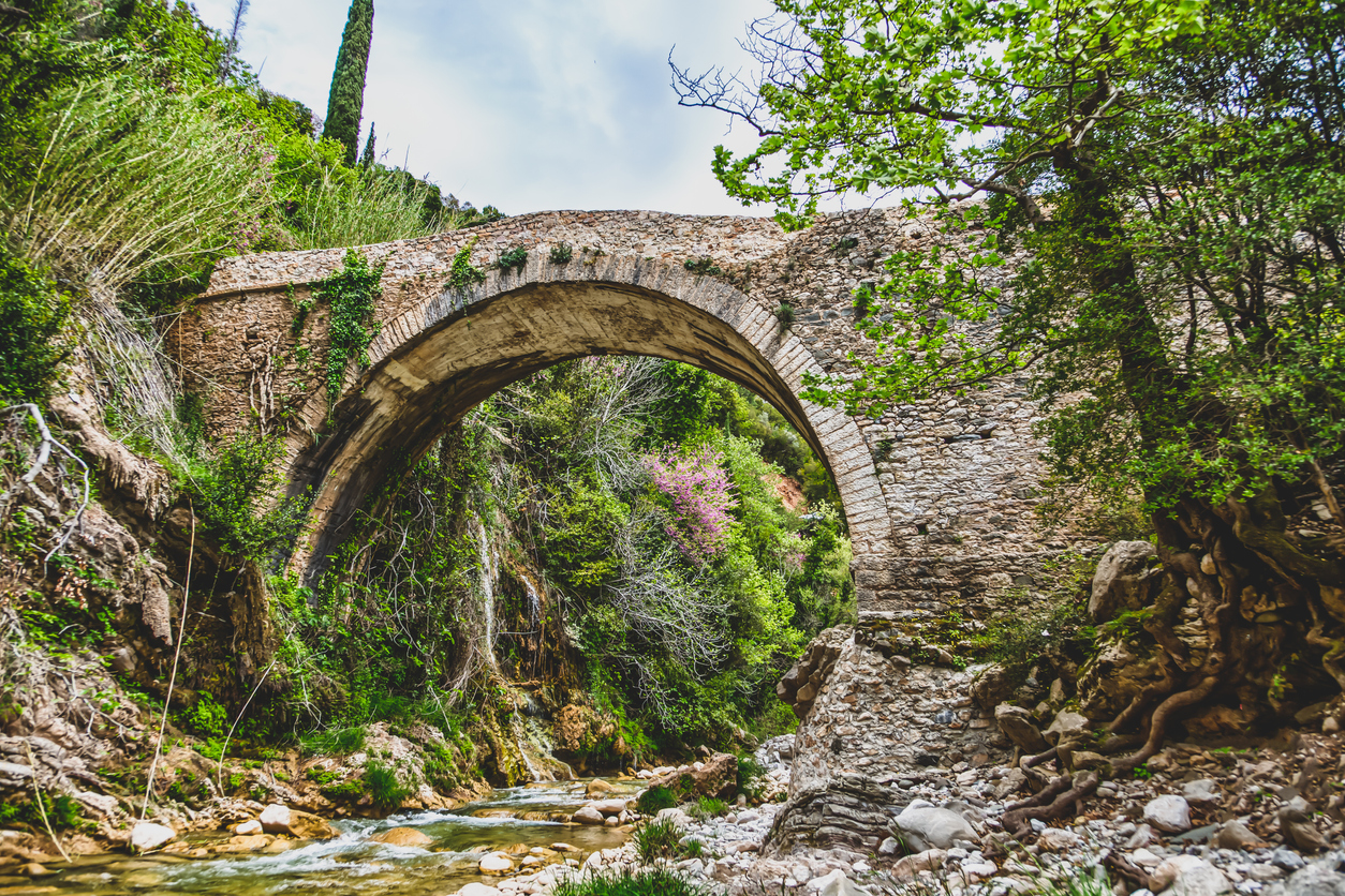Old stone arch bridge and water. Neda river Greece