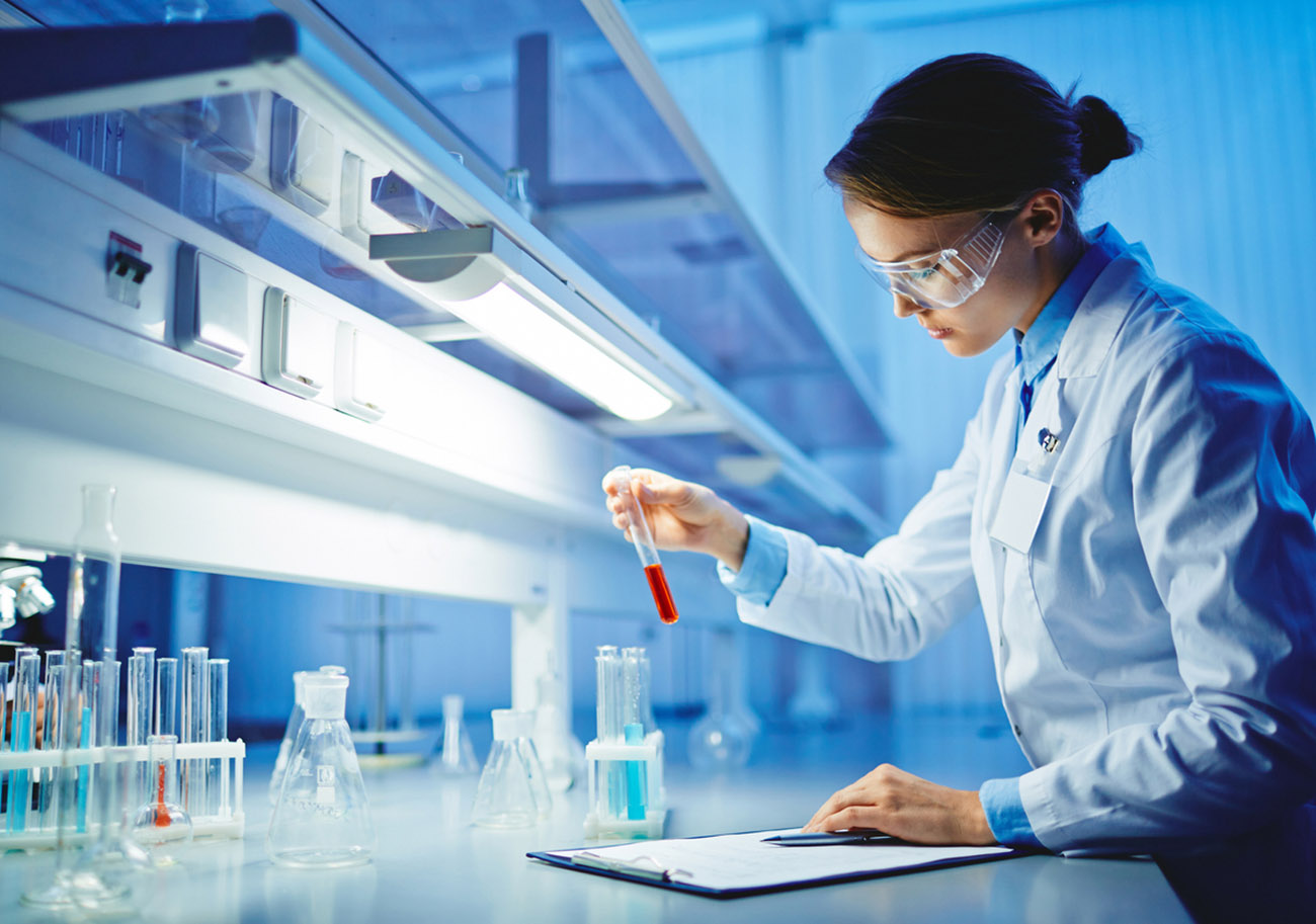 Young woman working with liquids in glassware