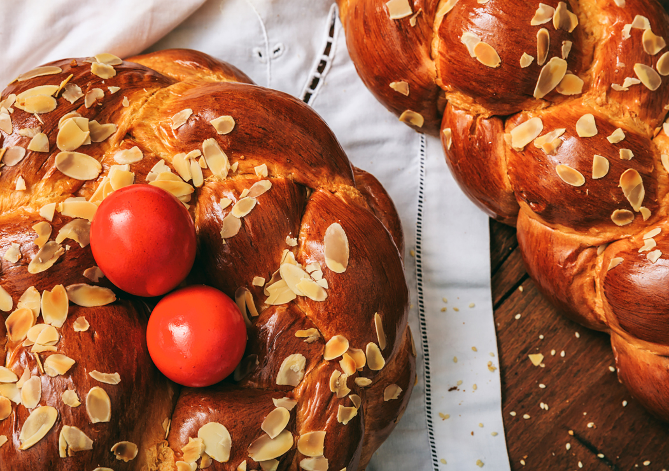 Easter traditional bread and red eggs on a table -  top view