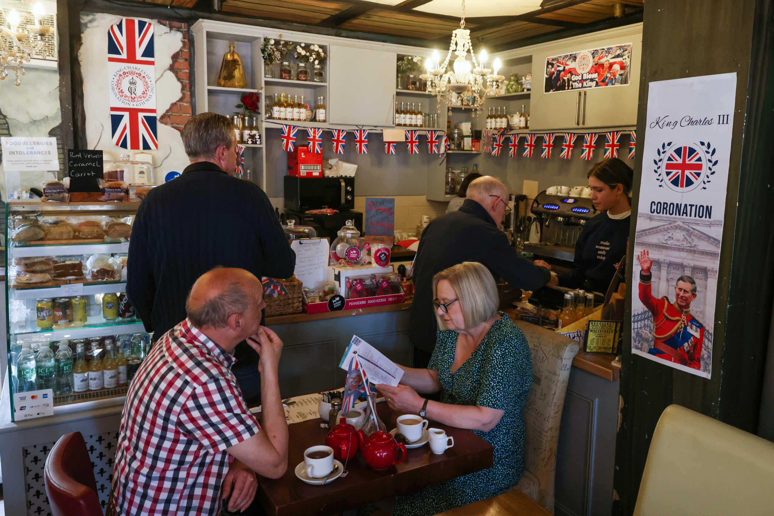 People sit in a cafe decorated for the Coronation of Britain's King Charles in Rochester, Britain, April 30, 2023.   REUTERS
