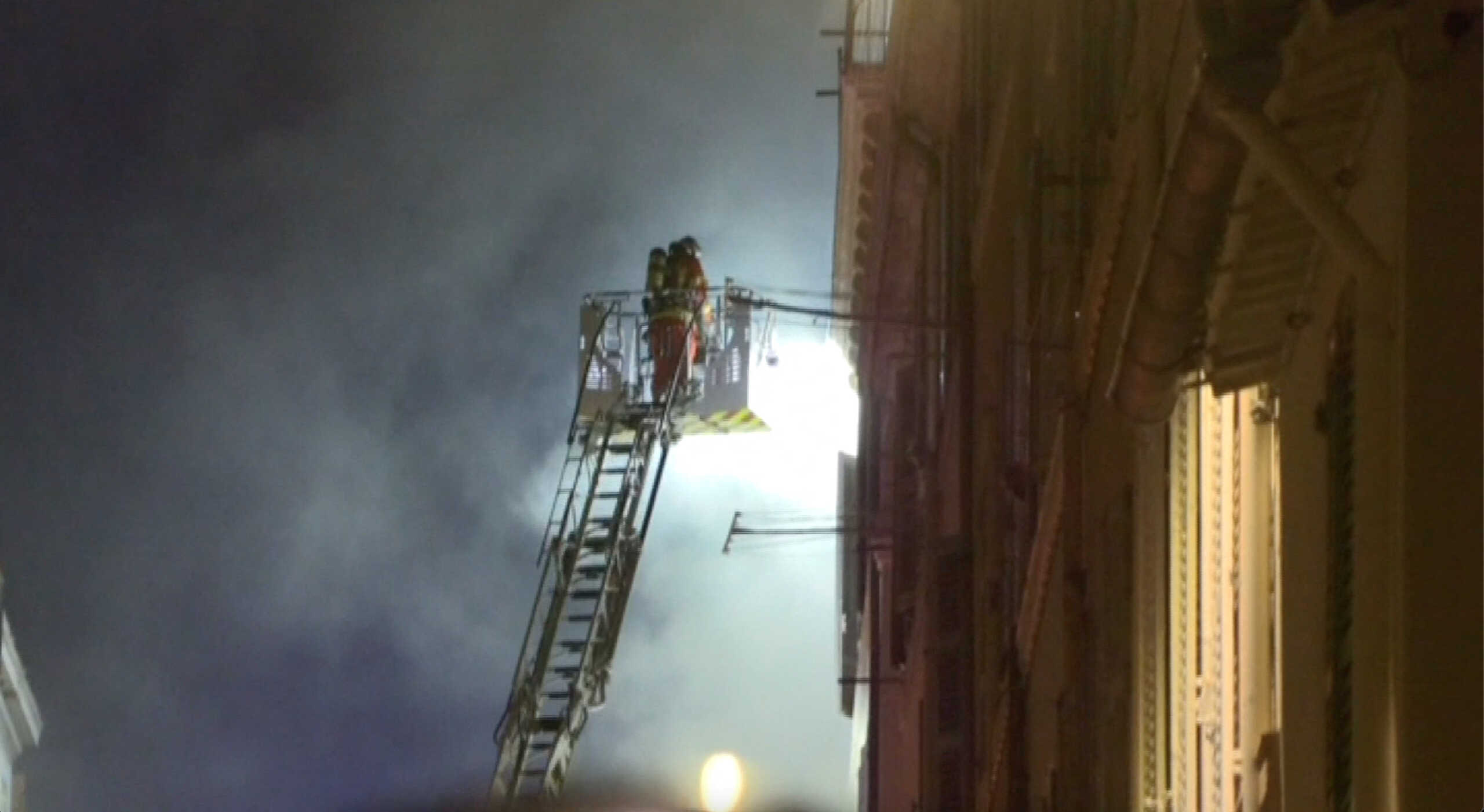 A firefighter works after a building collapsed in Marseille, France, April 9, 2023, in this screengrab obtained from a social media video. BFMTV