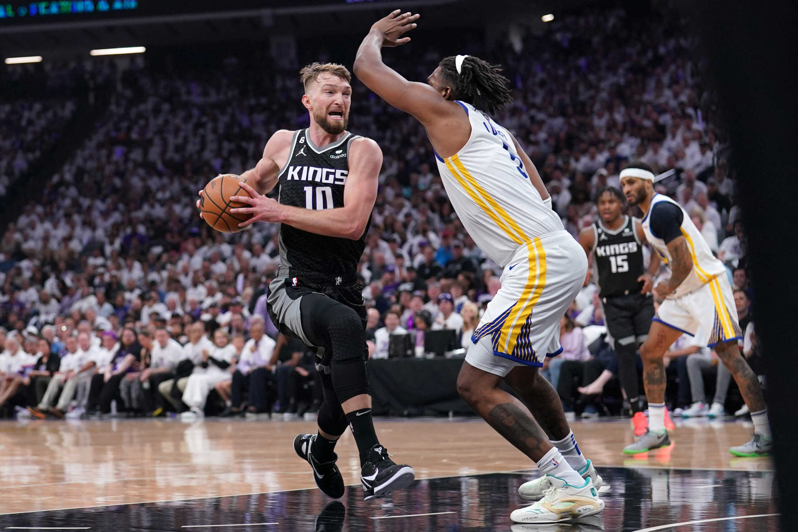 Apr 15, 2023; Sacramento, California, USA; Sacramento Kings forward Domantas Sabonis (10) drives past Golden State Warriors forward Kevon Looney (5) in the first quarter during game one of the 2023 NBA playoffs at the Golden 1 Center. Mandatory Credit: Cary Edmondson-USA TODAY Sports