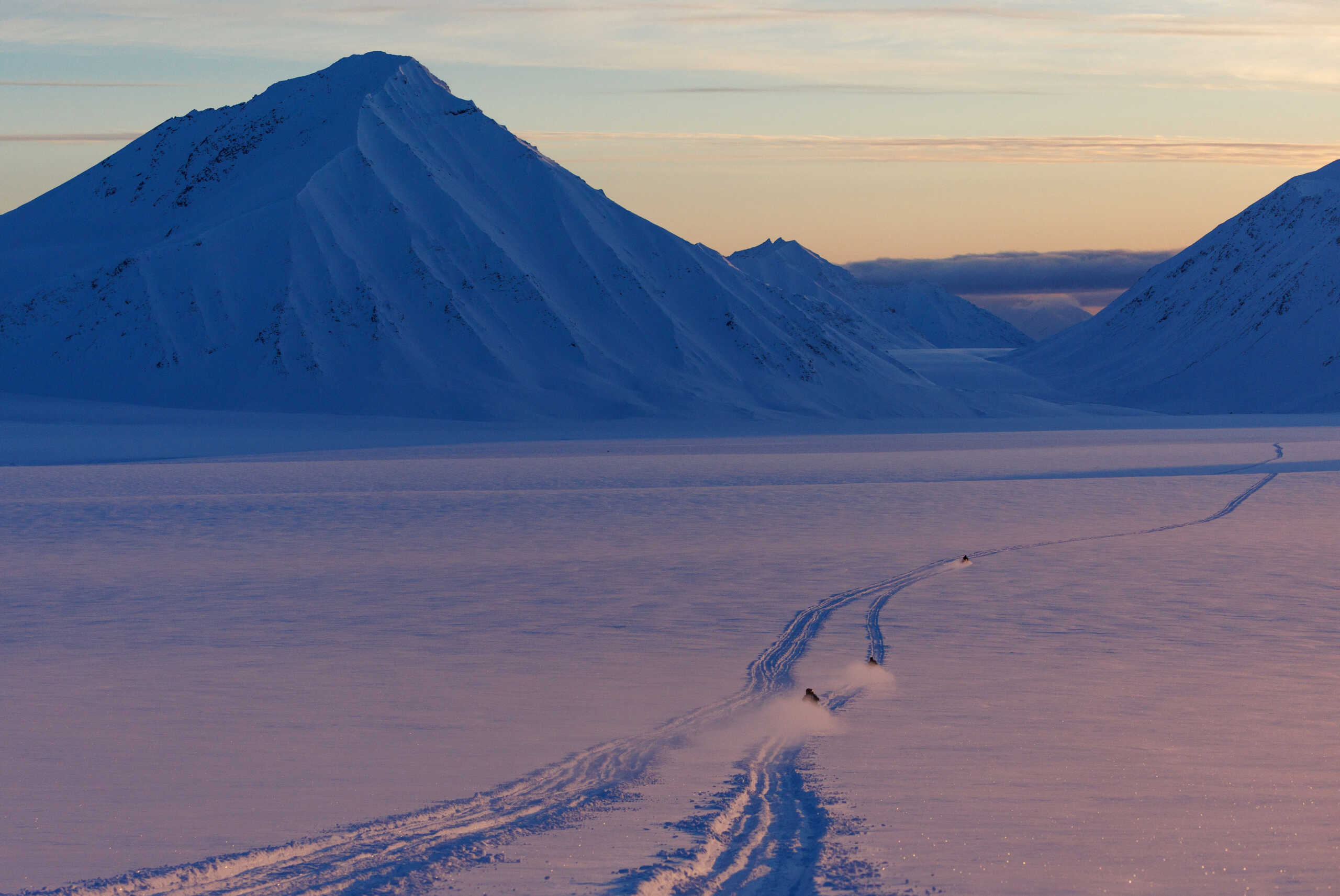 Scientists drive their snowmobiles cross the arctic during dawn near Ny-Alesund, Svalbard, Norway, April 10, 2023. REUTERS