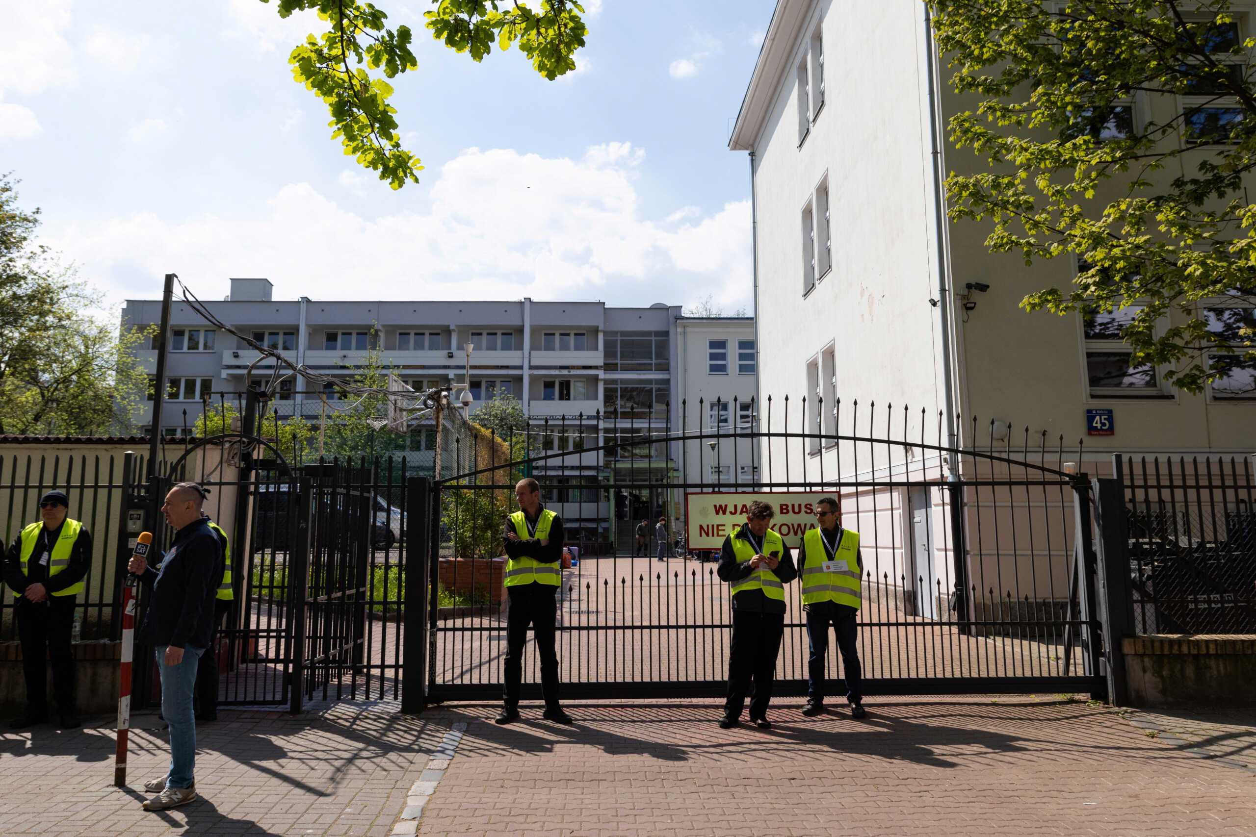 Security guards stand in front of the gate of the school belonging to the Russian embassy in Warsaw, Poland, April 29, 2023. REUTERS