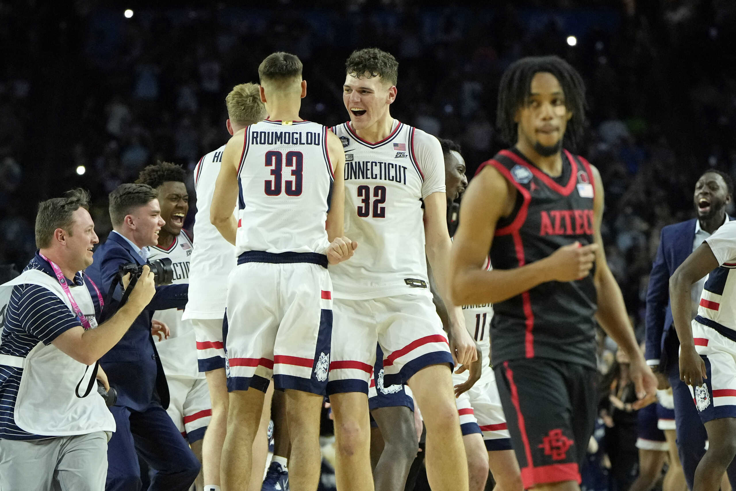 Apr 3, 2023; Houston, TX, USA; Connecticut Huskies center Donovan Clingan (32) celebrates with guard Apostolos Roumoglou (33) after their win against the San Diego State Aztecs in the national championship game of the 2023 NCAA Tournament at NRG Stadium. Mandatory Credit: Bob Donnan-USA TODAY Sports