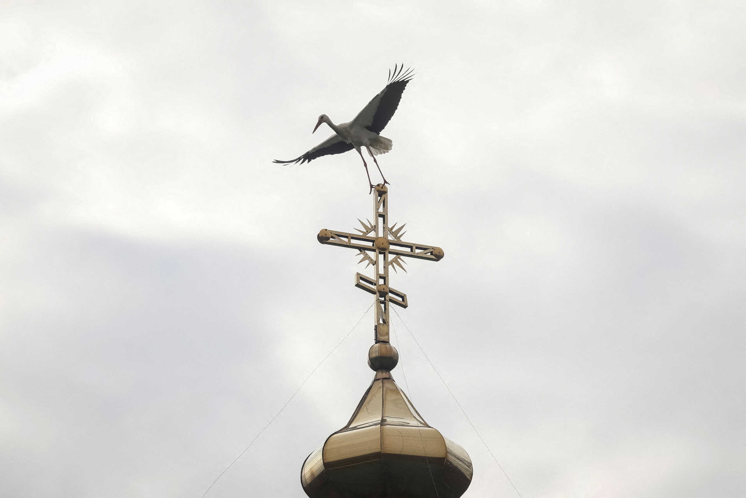 FILE PHOTO: A stork sits on the cross of an Orthodox Church of Ukraine church, amid Russia's attack on Ukraine, in the village of Hrabivtsi, Vinnytsia region, Ukraine April 23, 2023. REUTERS