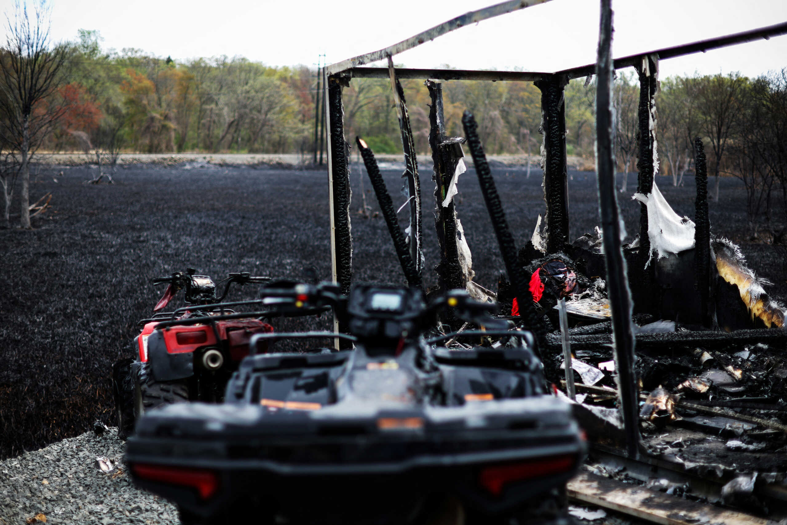 Burned ATV vehicles and a trailer sit next to the Congers bird sanctuary area where, according to local reports, sparks from a CSX train traveling through the area caused dozens of brush fires, and about 100 families voluntarily evacuated their homes, in Rockland county in Congers, New York, U.S., April 15, 2023. REUTERS