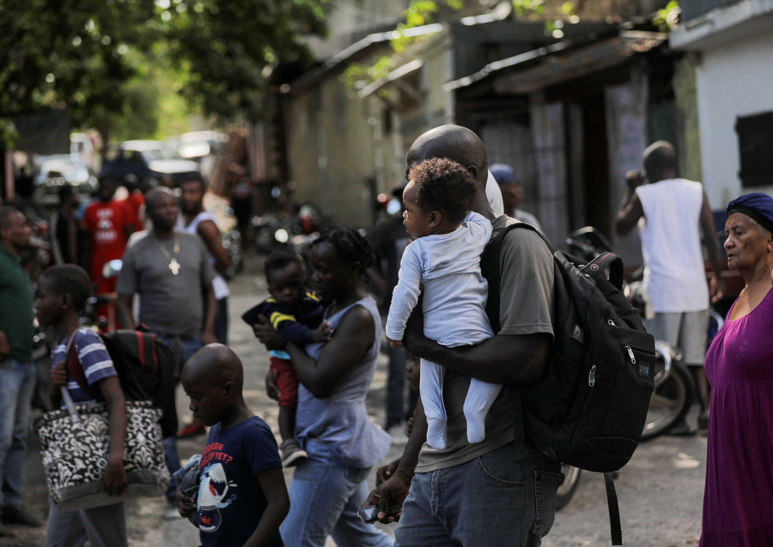 People carry their belongings while fleeing their homes and neighbourhood due to clashes between gangs, in Port-au-Prince, Haiti April 24, 2023. REUTERS