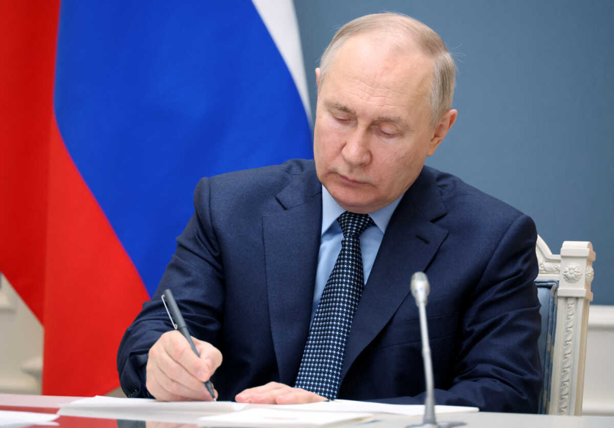 Russian President Vladimir Putin writes during a video conference meeting to discuss agricultural issues including spring field operations in Moscow, Russia, May 18, 2023. Sputnik