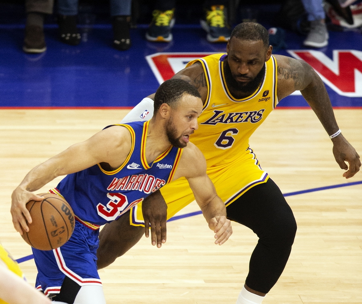 epa09751491 Golden State Warriors guard Stephen Curry (L) drives past Los Angeles Lakers forward LeBron James (R) during the second half of their NBA game at Chase Center in San Francisco, California, USA, 12 February 2022.  EPA