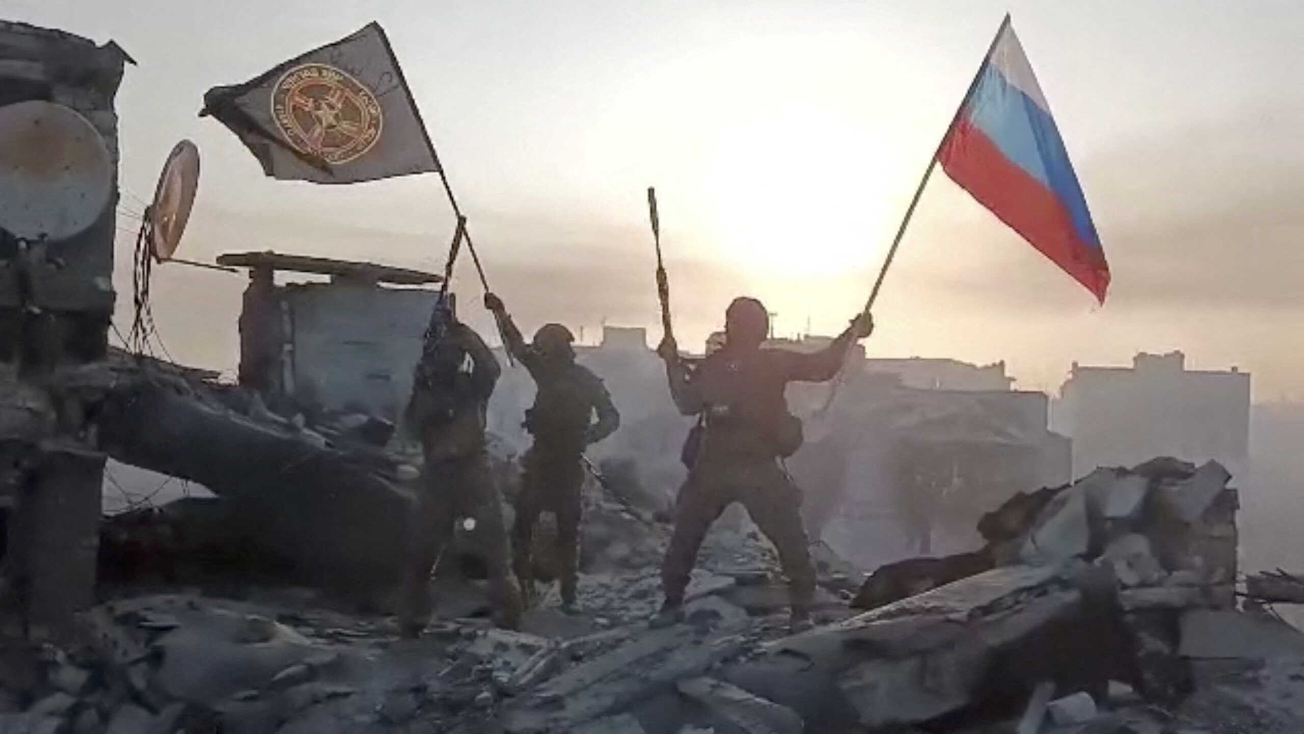 Wagner mercenary group fighters wave flags of Russia and Wagner group on top of a building in an unidentified location, in the course of the Russia-Ukraine conflict, in this still image obtained from a video released on May 20, 2023, along with a statement by Russian mercenary chief Yevgeny Prigozhin about taking full control of the Ukrainian city of Bakhmut. Press service of "Concord"