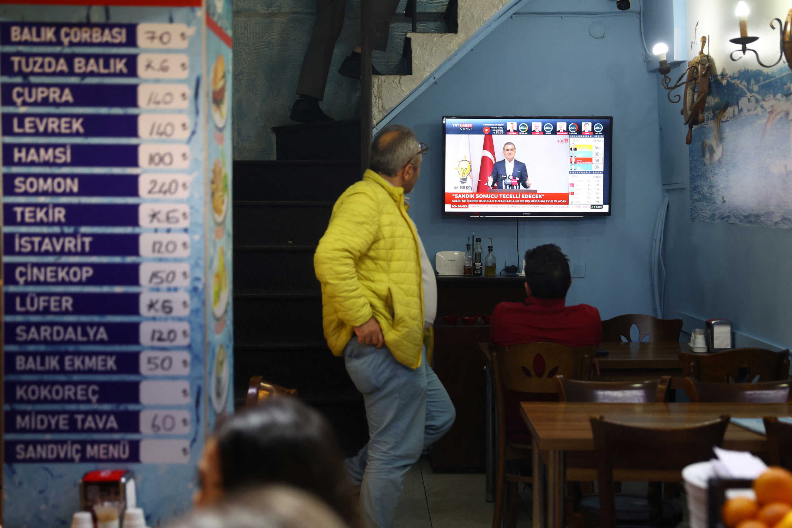 People watch the Turkish presidential and parliamentary elections on a TV screen in Istanbul, Turkey May 14, 2023. REUTERS