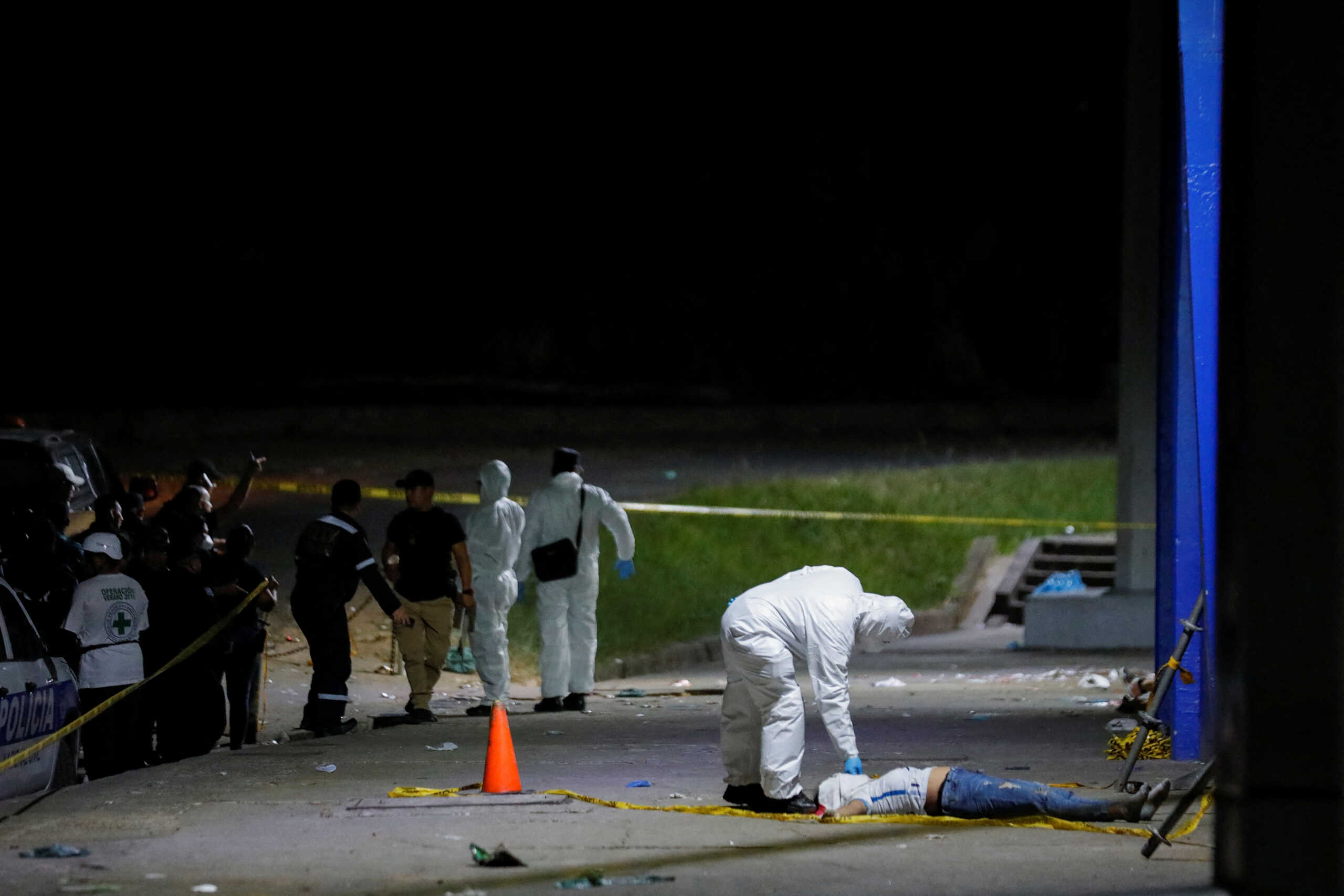 SENSITIVE MATERIAL. THIS IMAGE MAY OFFEND OR DISTURB A member of the forensic team examines the body of a fan who was killed in a stampede prior to a soccer game between C.D. FAS Vs. Alianza F.C. at the Cuzcatlan stadium, in San Salvador, El Salvador May 20, 2023. REUTERS